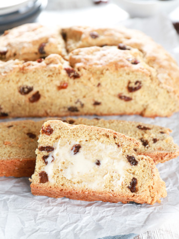 Slices of Irish Soda Bread with the loaf in the background. Recipe from A Kitchen Addiction