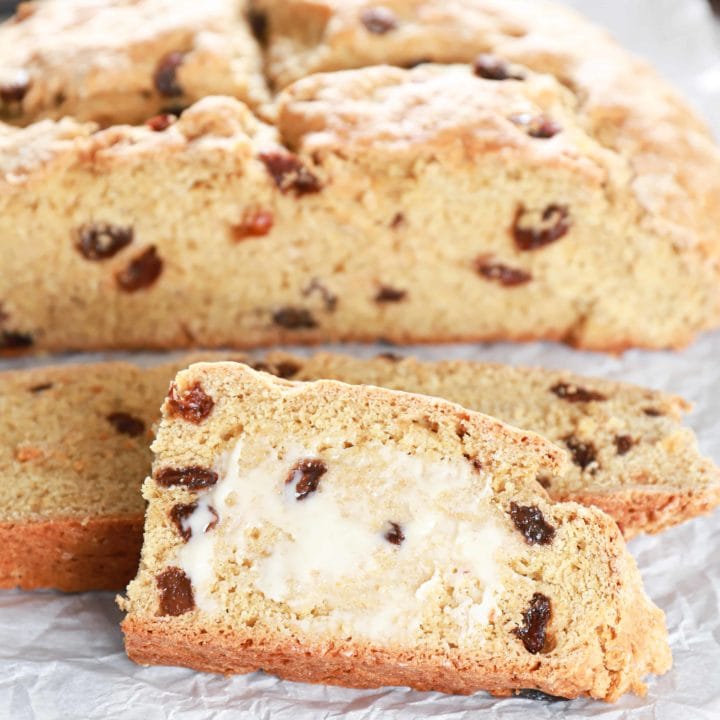 Slices of Irish Soda Bread with the loaf in the background. Recipe from A Kitchen Addiction