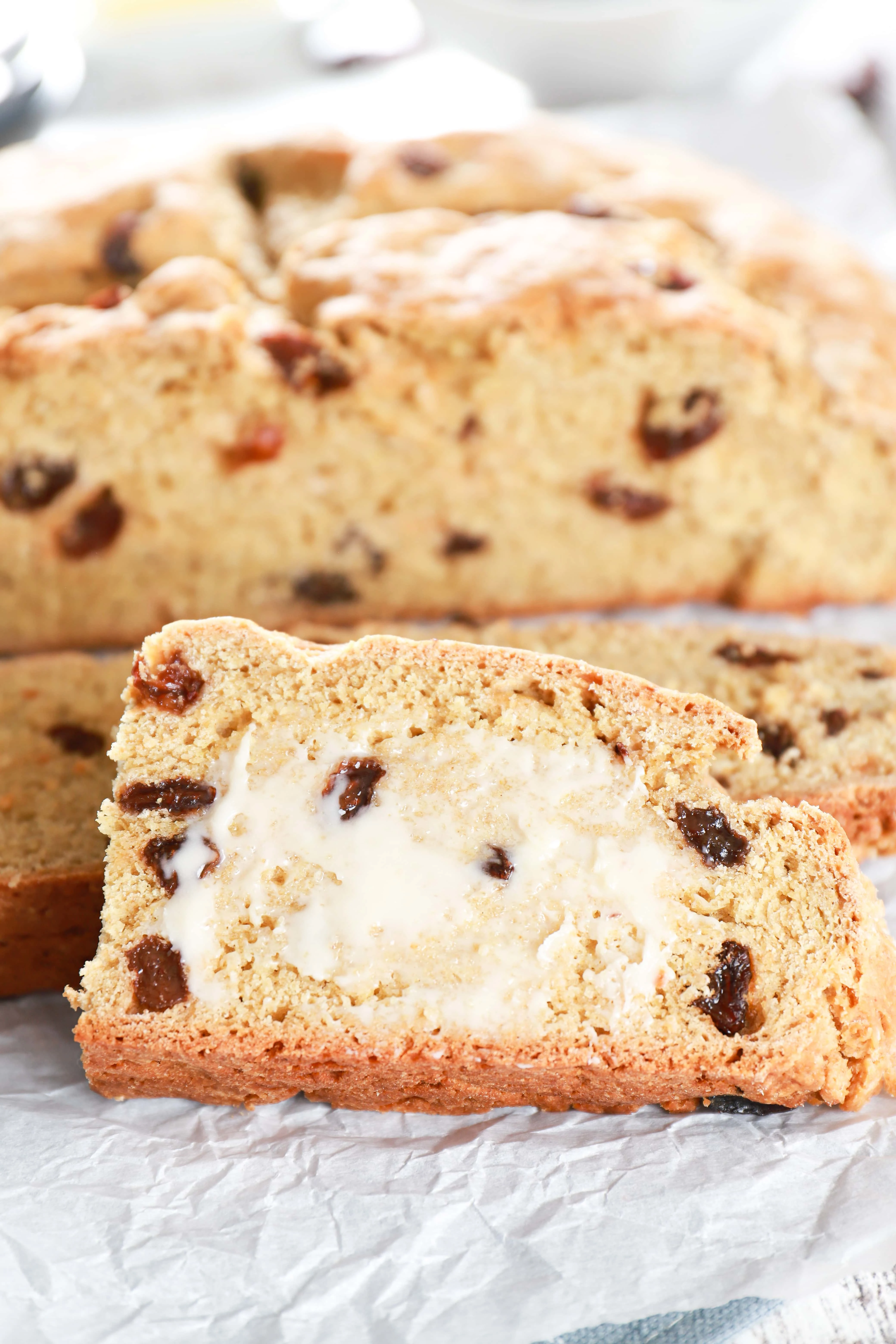 Up close image of a piece of buttered Irish Soda Bread. Recipe from A Kitchen Addiction