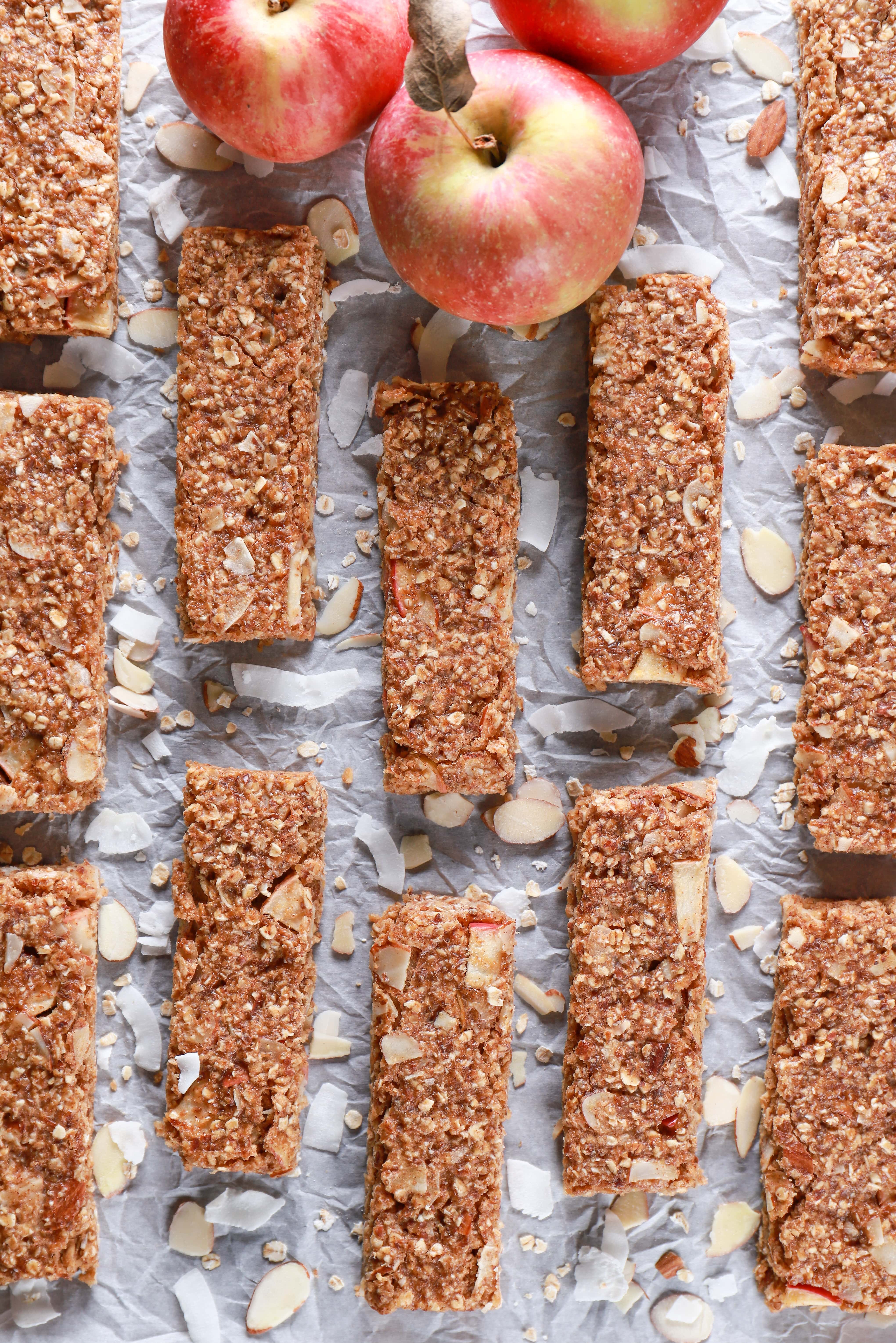 Overhead view of soft baked apple almond granola bars on parchment paper. Recipe from A Kitchen Addiction