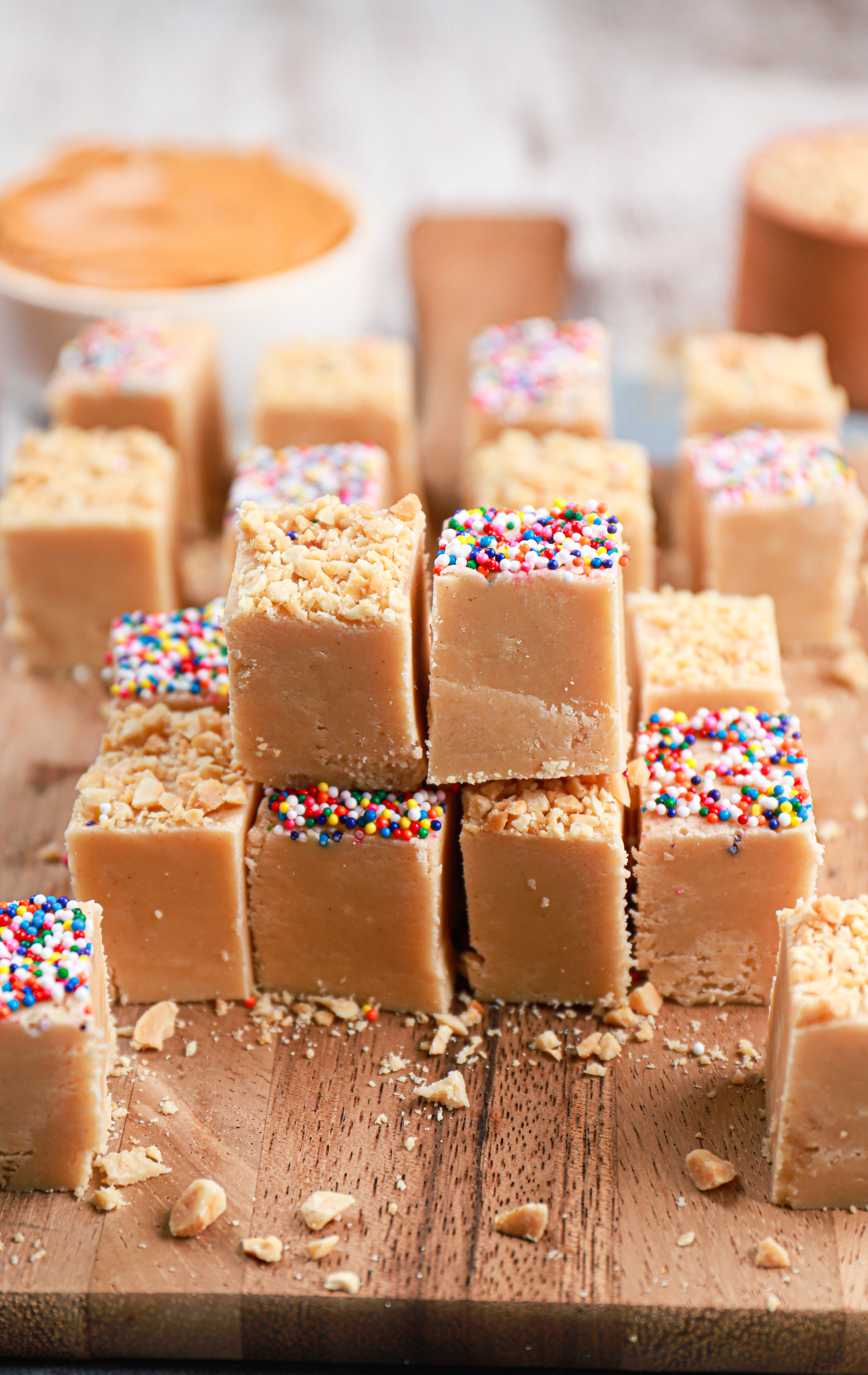 A stack of peanut butter fudge on a wooden cutting board.