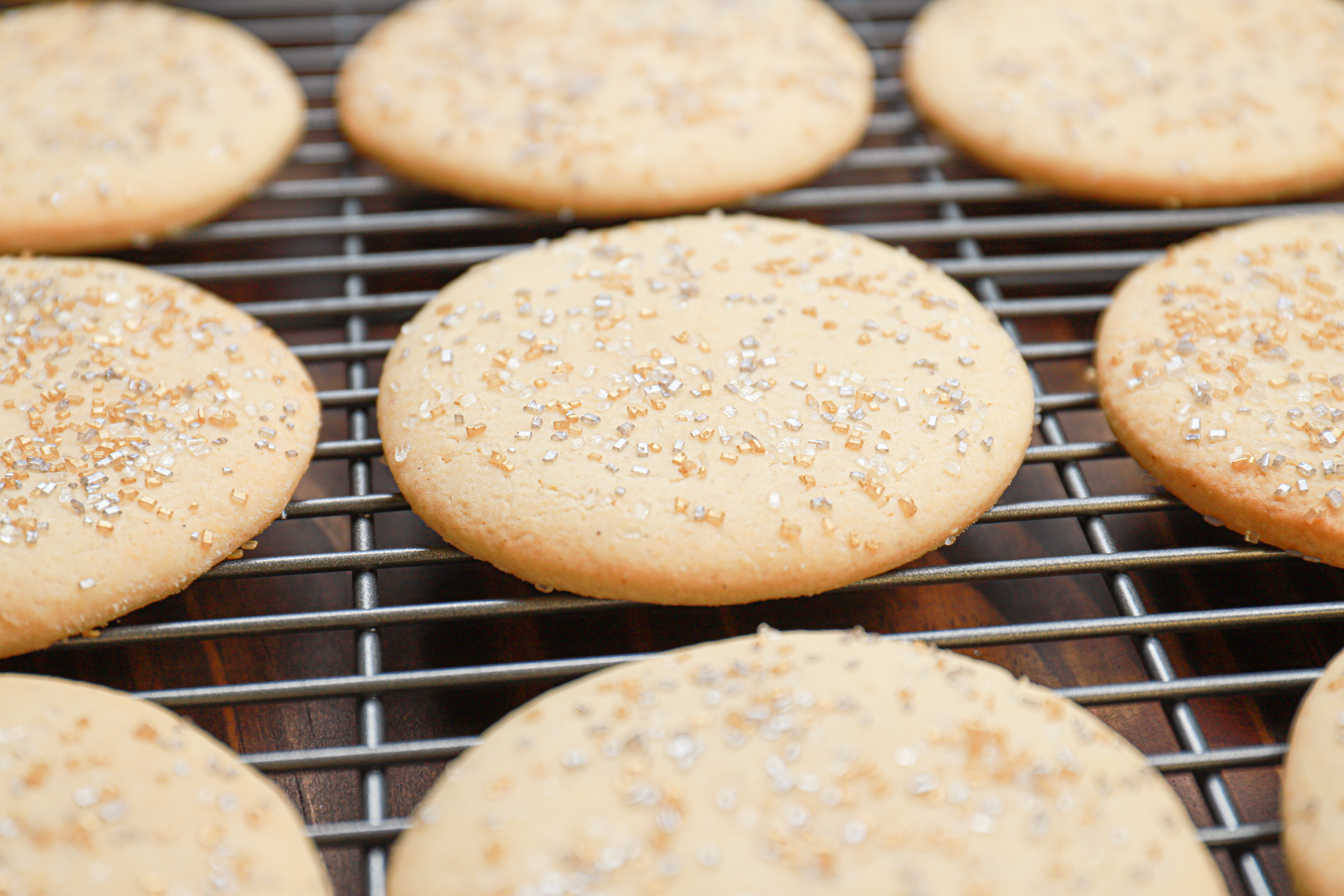Side view of a cut out sour cream cookie on a wire cooling rack.