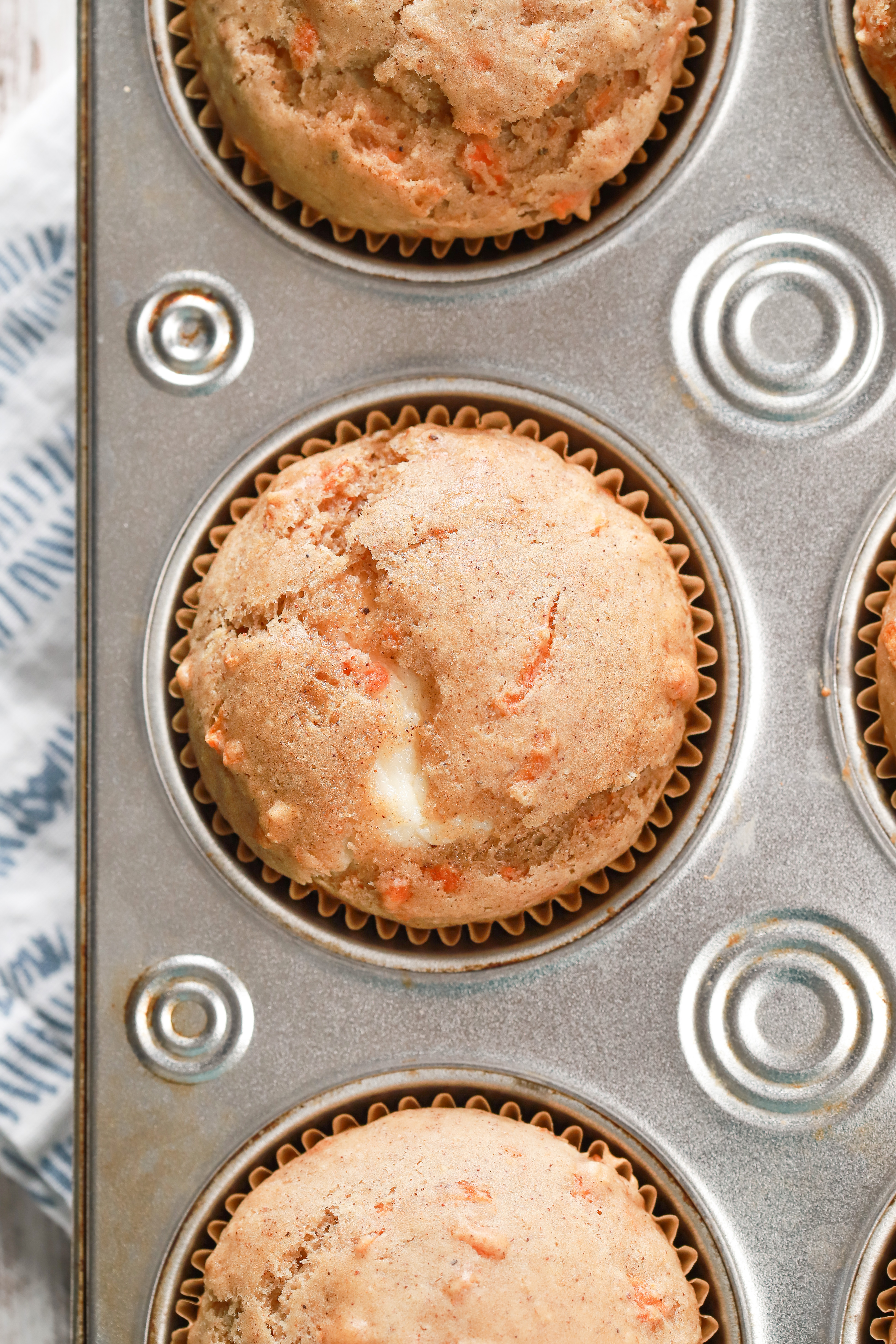 Up close overhead view of the top of a carrot cake muffin with cream cheese filling.