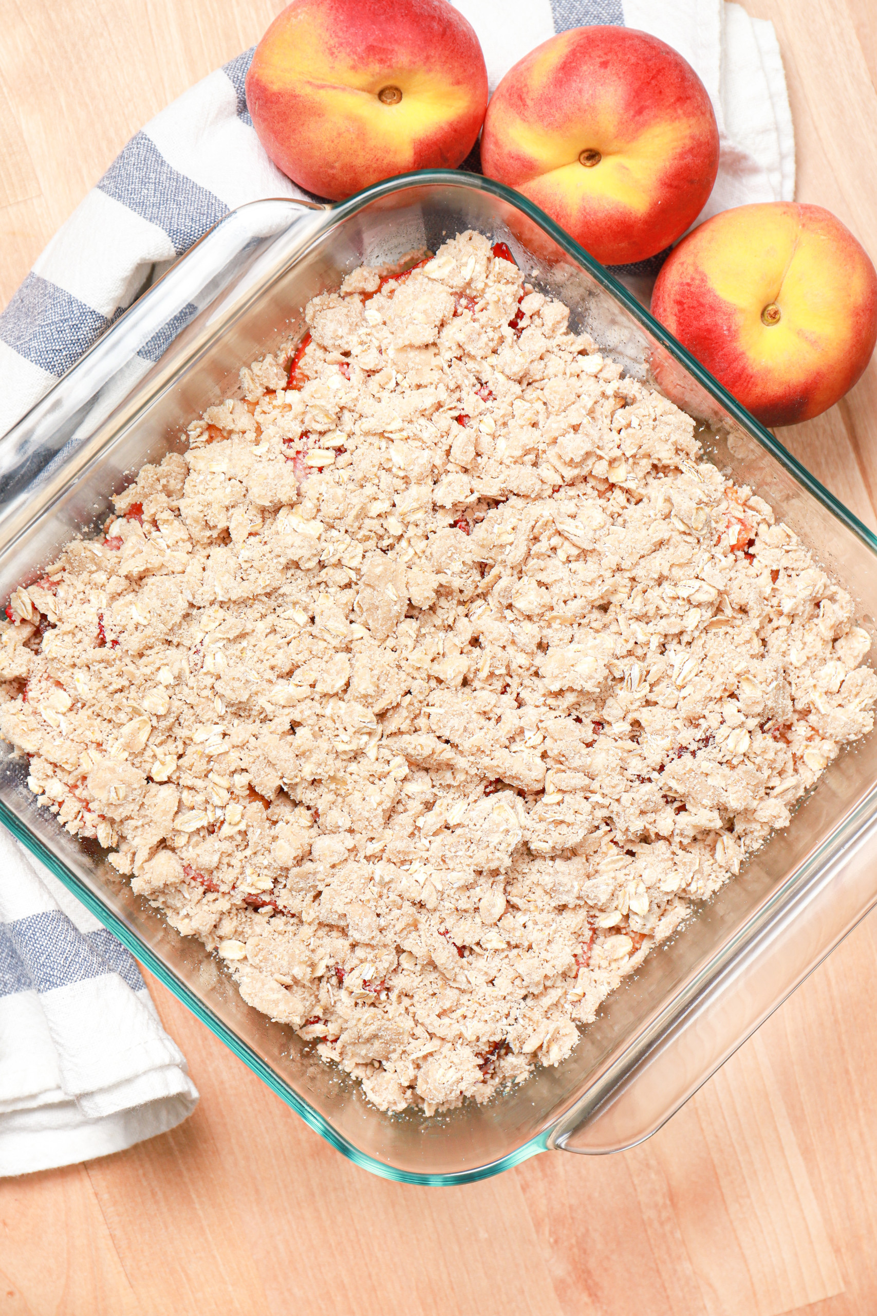 Overhead view of a pan of strawberry peach streusel bars before they are baked.