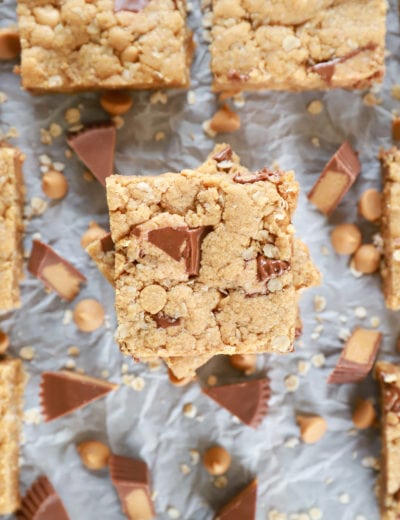 Overhead view of a stack of Peanut Butter Overload Cookie Bars on parchment paper.