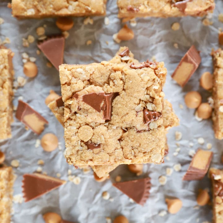 Overhead view of a stack of Peanut Butter Overload Cookie Bars on parchment paper.