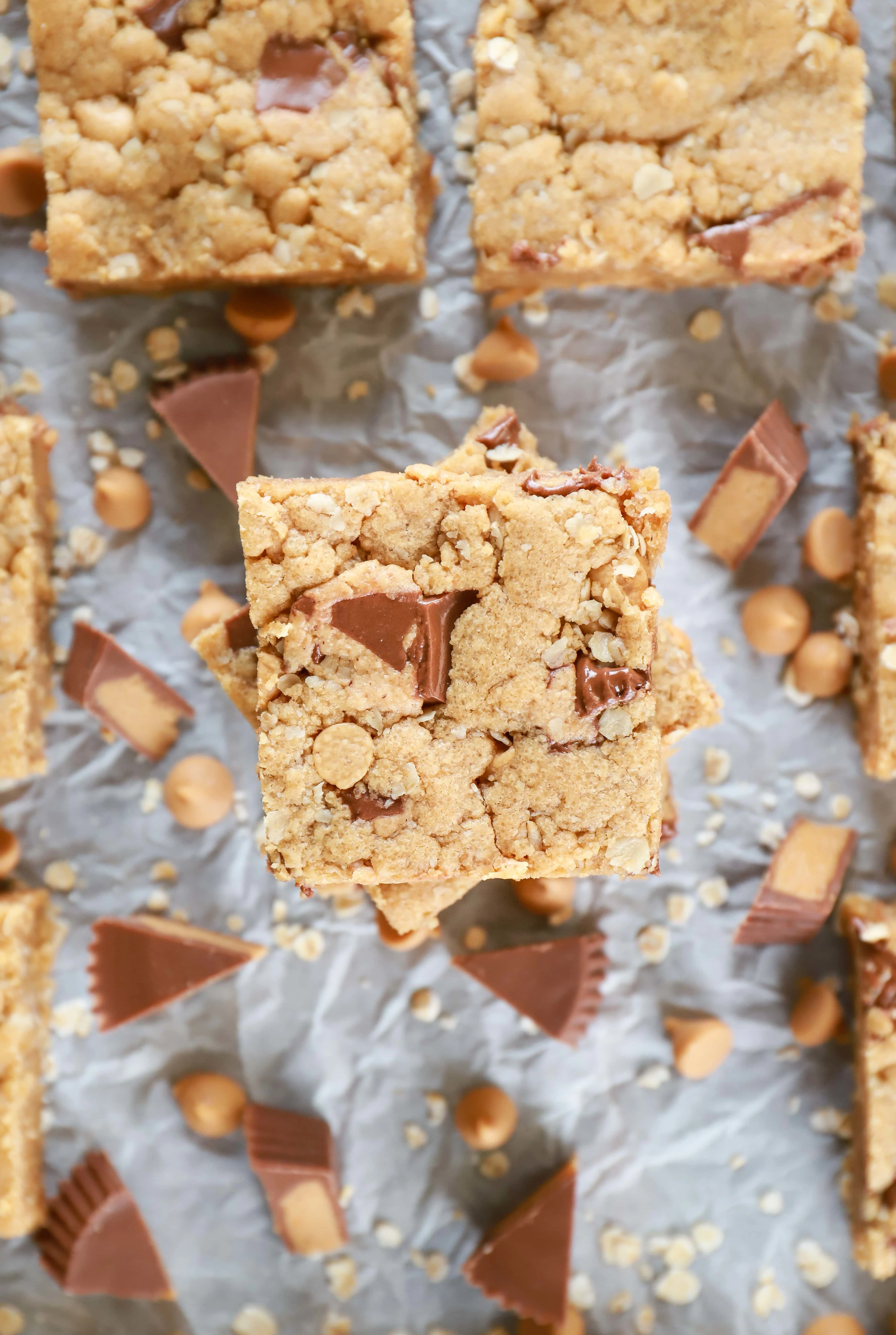 Overhead view of a stack of Peanut Butter Overload Cookie Bars on parchment paper.