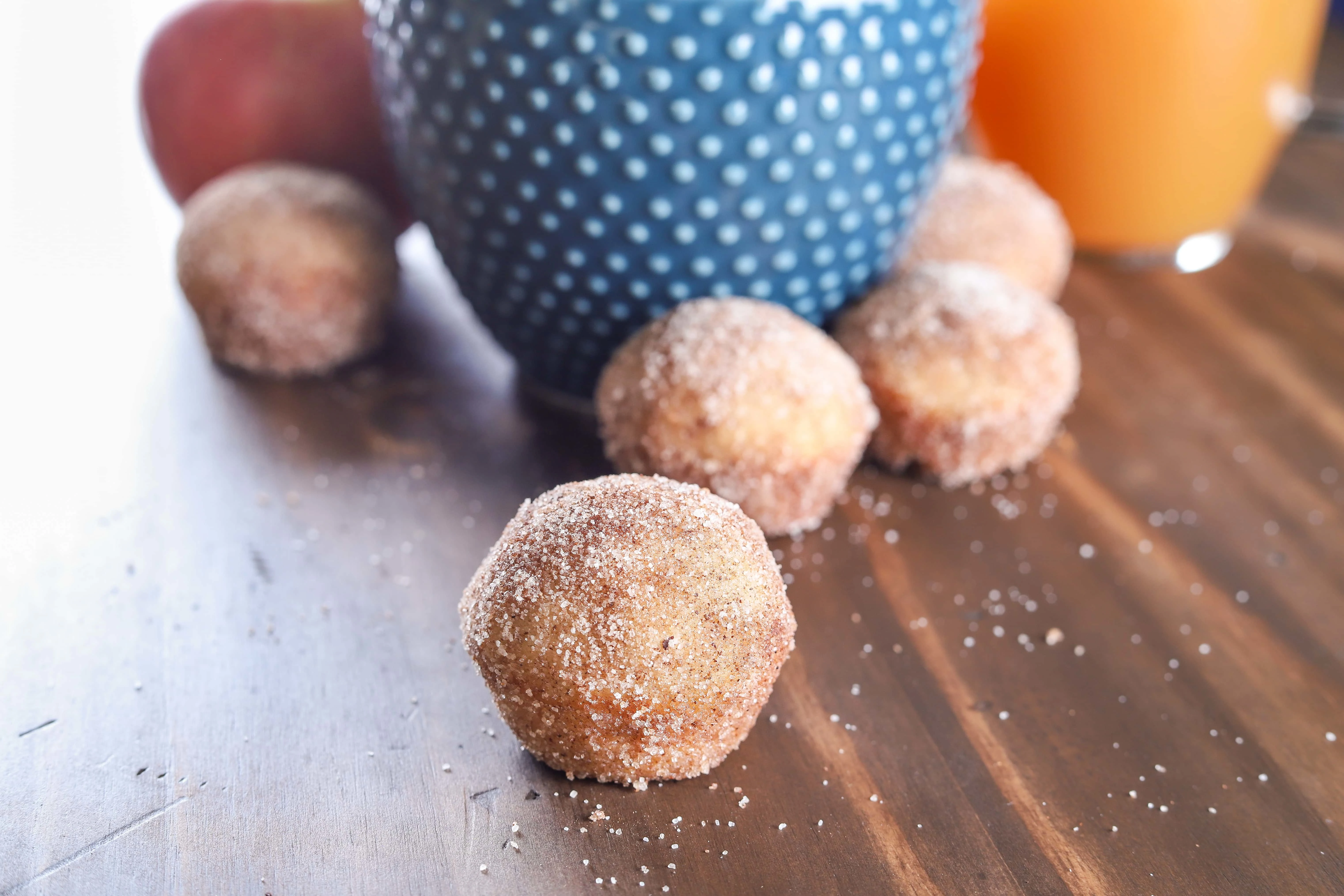 Spiced Apple Cider Mini Donut Muffins with a glass of apple cider. Recipe from A Kitchen Addiction
