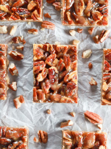 Above view of a batch of honey pecan pie bars cut and arranged on parchment paper