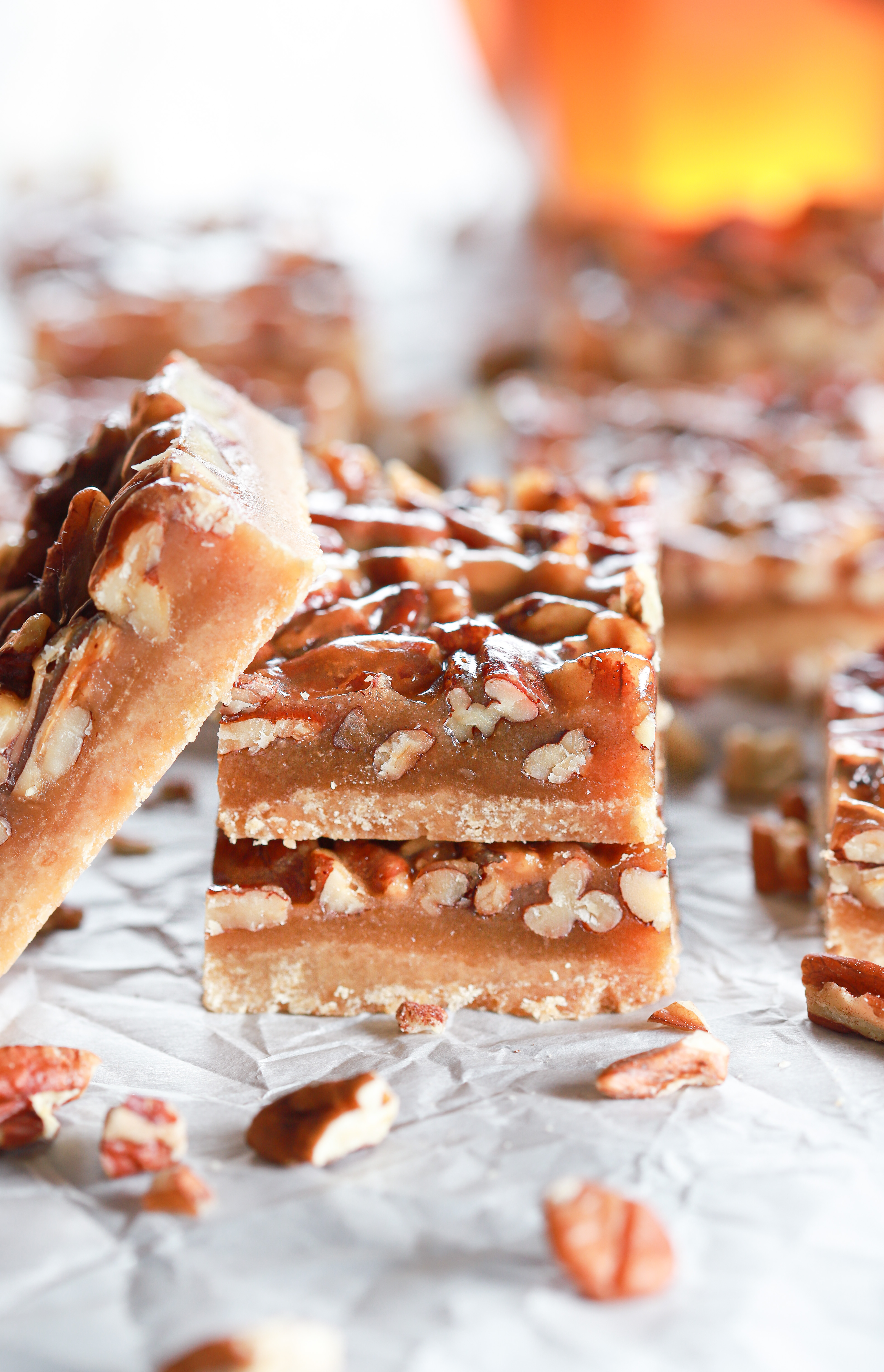 stack of honey pecan pie bars with more bars in the background