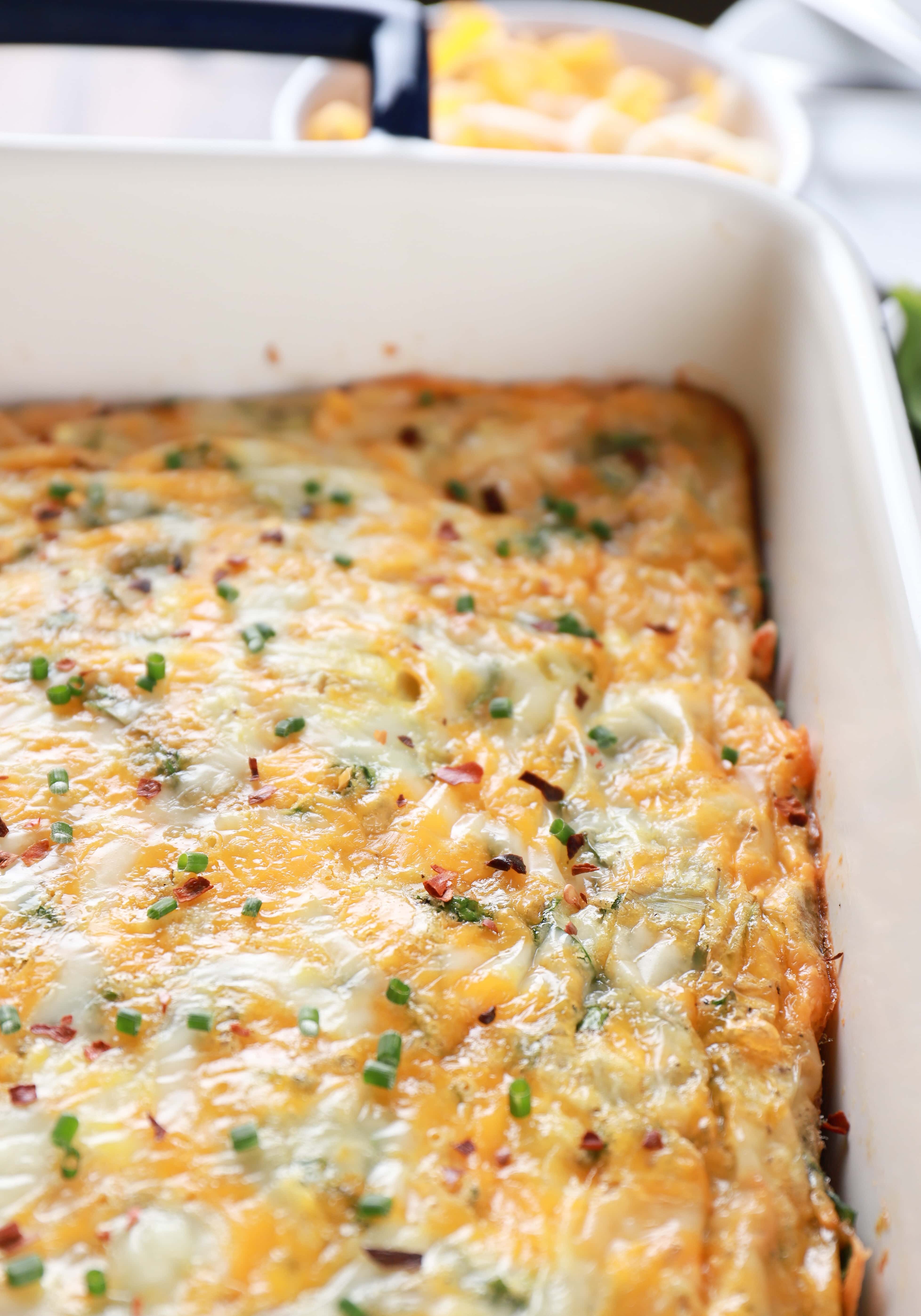 Pan of cheesy spinach and artichoke egg bake. Recipe from A Kitchen Addiction