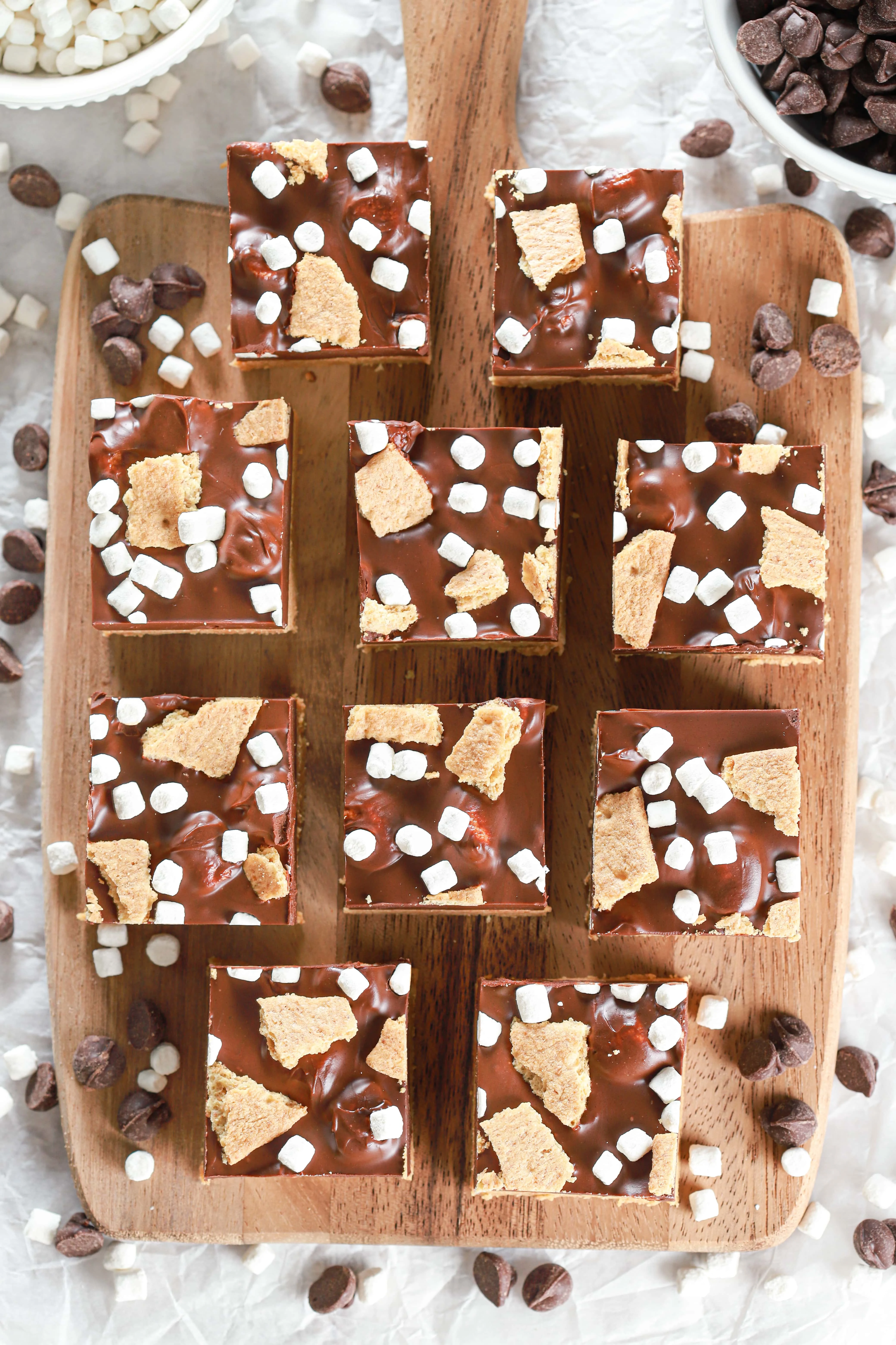 Overhead view of a batch of no bake peanut butter smores bars on a wooden cutting board.