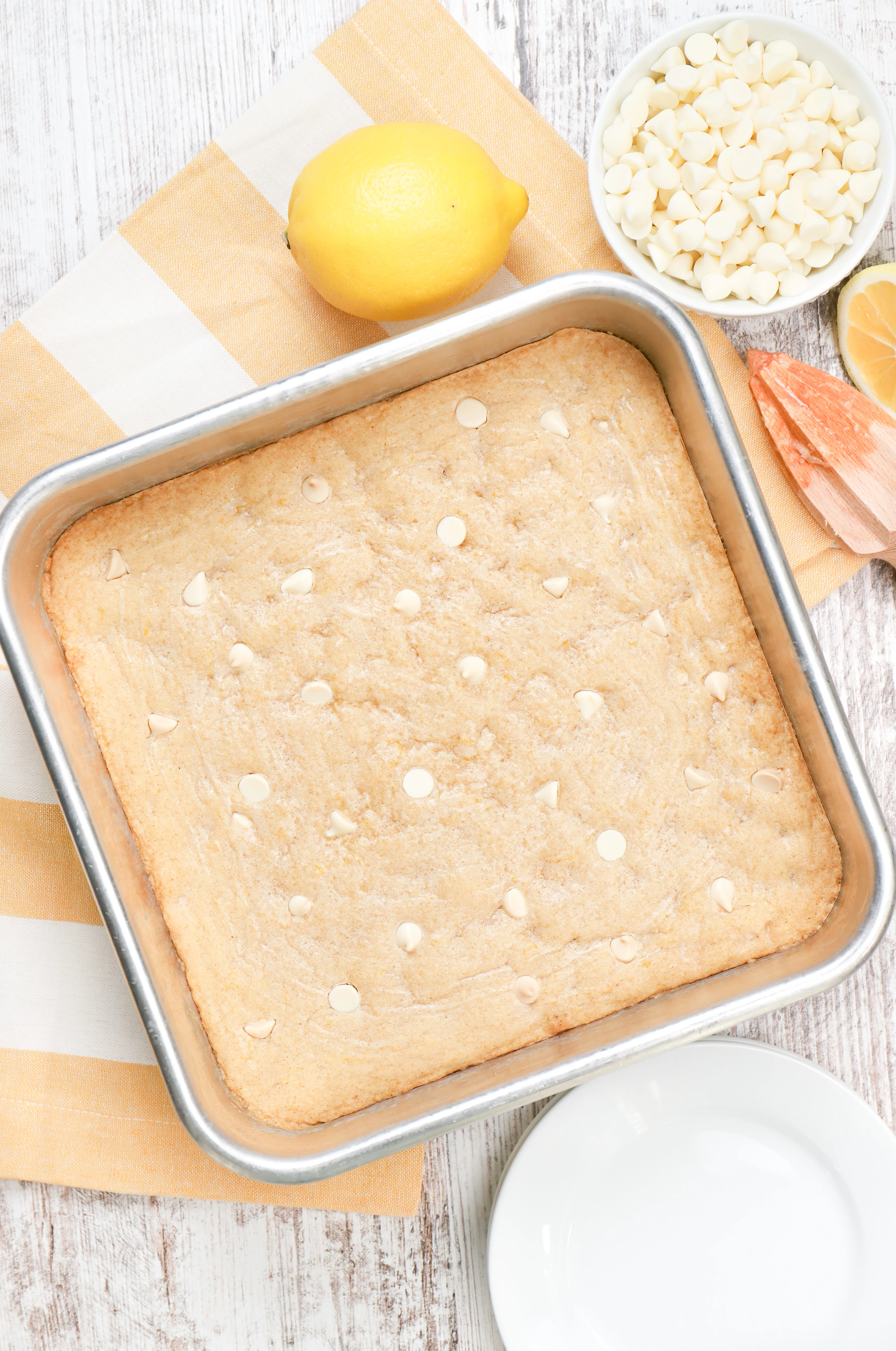 Overhead view of a batch of white chocolate lemon blondies in an aluminum baking dish.