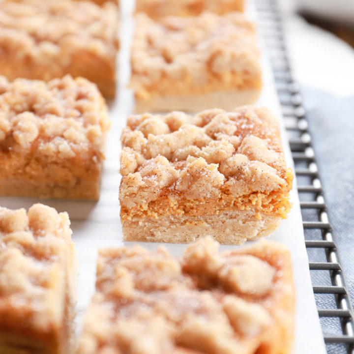 Up close side view of a pumpkin snickerdoodle cheesecake bar. Recipe from A Kitchen Addiction