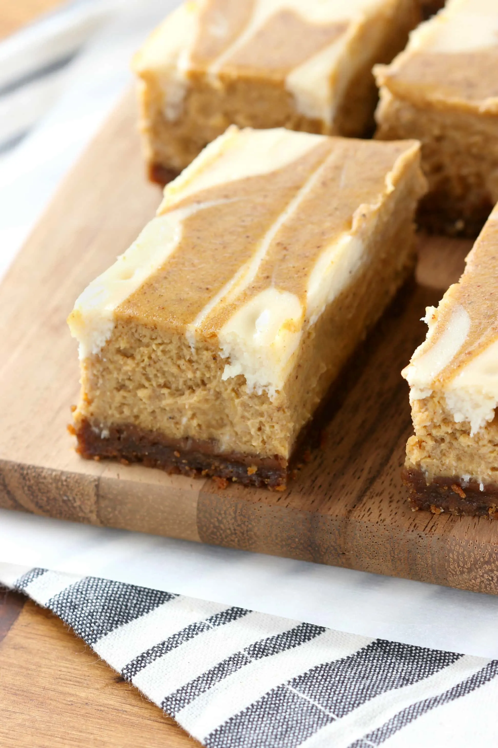 Creamy Swirled Pumpkin Cheesecake Bars with Gingersnap Crust Recipe from A Kitchen Addiction