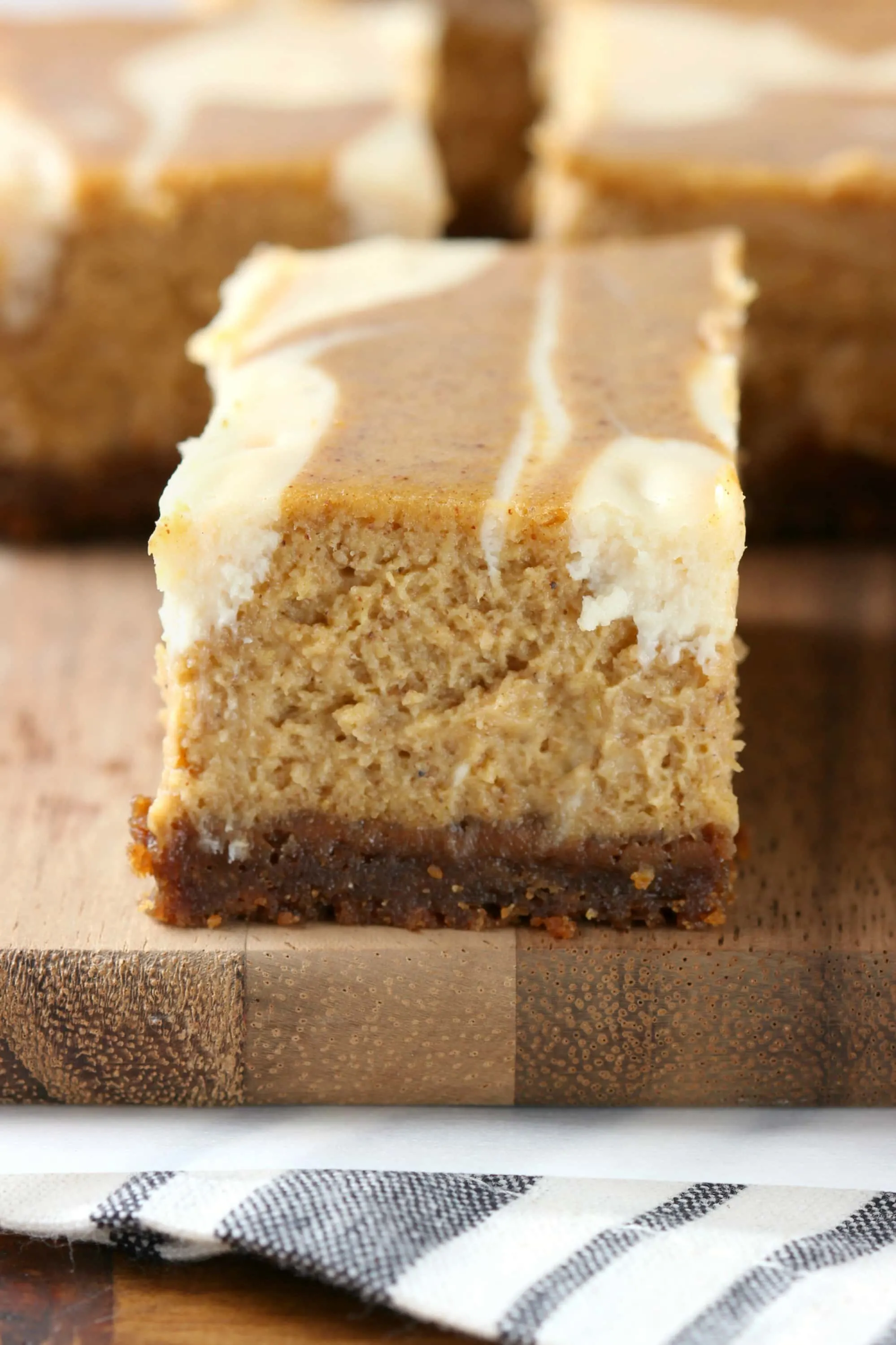 Creamy Swirled Pumpkin Cheesecake Bars with Gingersnap Crust Recipe from A Kitchen Addiction