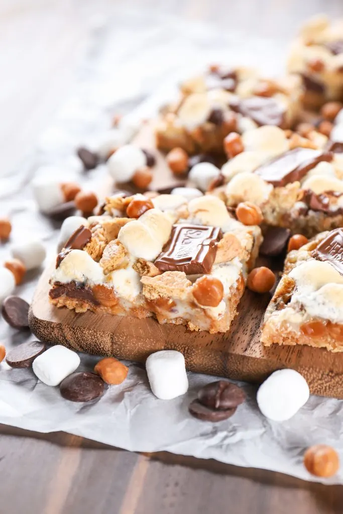 Caramel Smores Seven Layer Bars on a cutting board. Recipe for seven layer bars from A Kitchen Addiction.