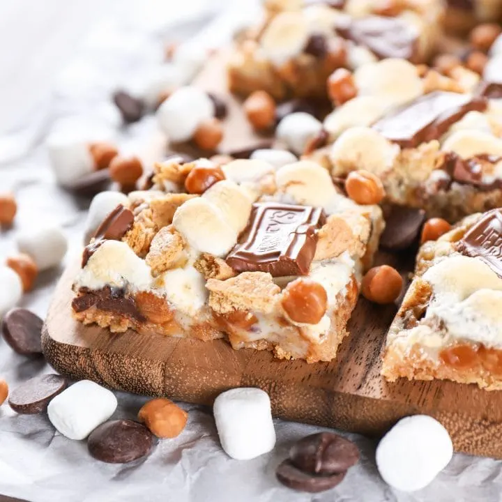 Caramel Smores Seven Layer Bars on a cutting board. Recipe for seven layer bars from A Kitchen Addiction.