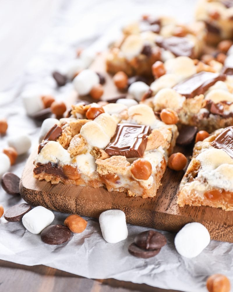Caramel Smores Seven Layer Bars on a cutting board. Recipe for seven layer bars from A Kitchen Addiction.