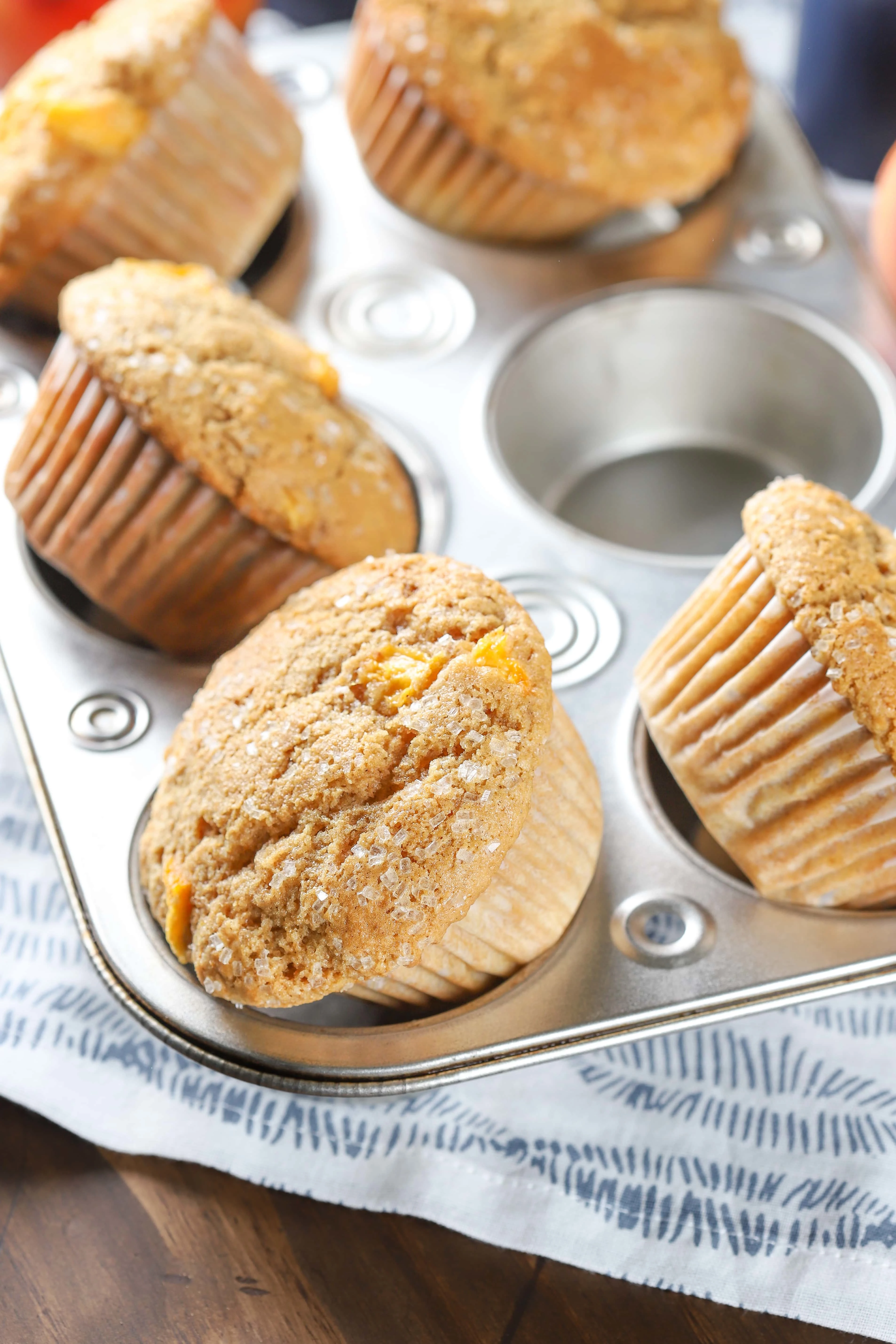Bakery Style Peach Cardamom Muffins in a muffin tin. Recipe from A Kitchen Addiction