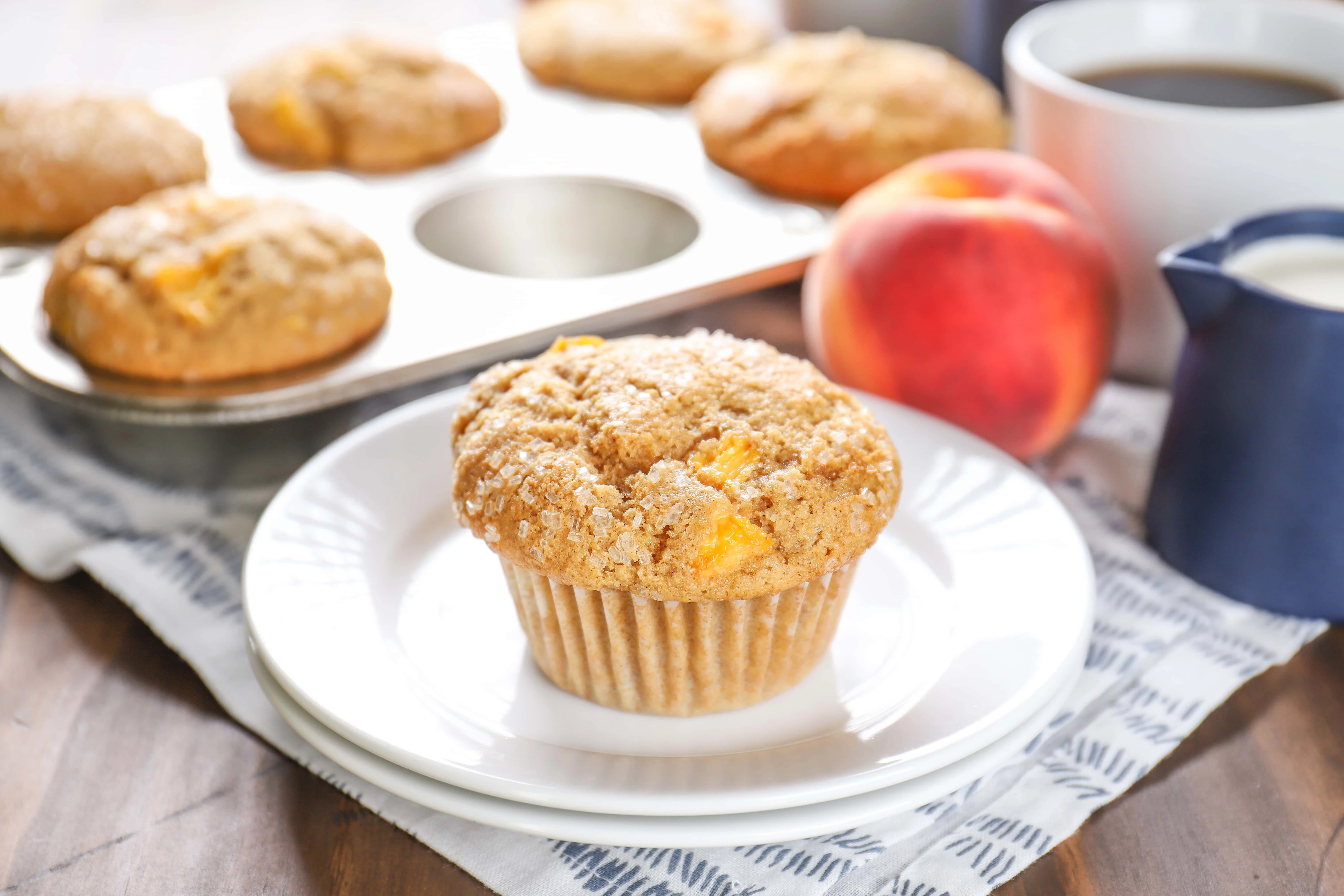 Peach Cardamom Muffins on a plate. Recipe from A Kitchen Addiction