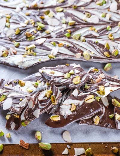 Pieces of Swirled Dark Chocolate Almond Pistachio Bark on a baking sheet.