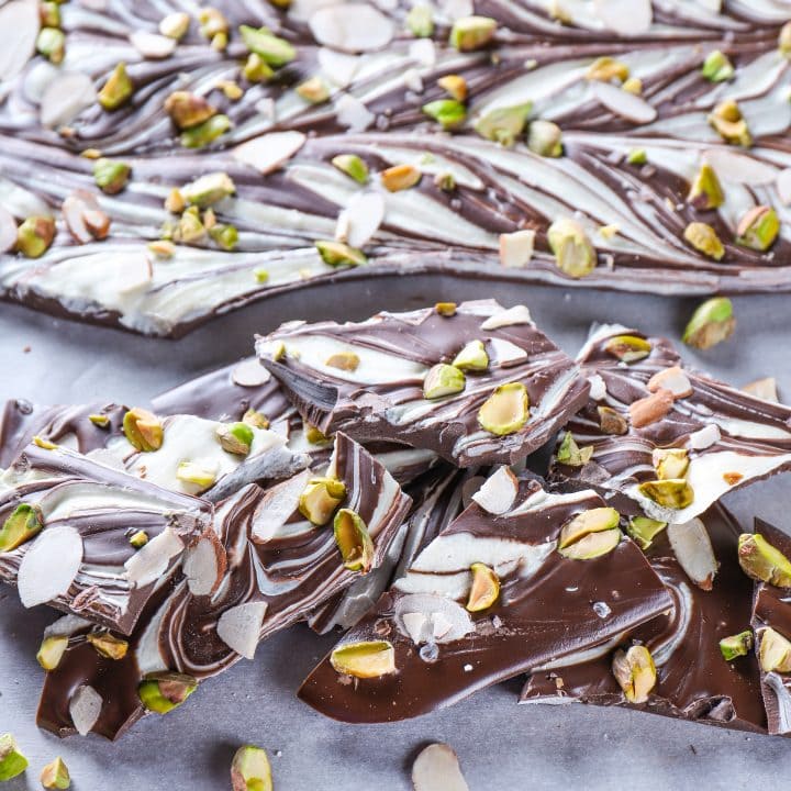 Pieces of Swirled Dark Chocolate Almond Pistachio Bark on a baking sheet.