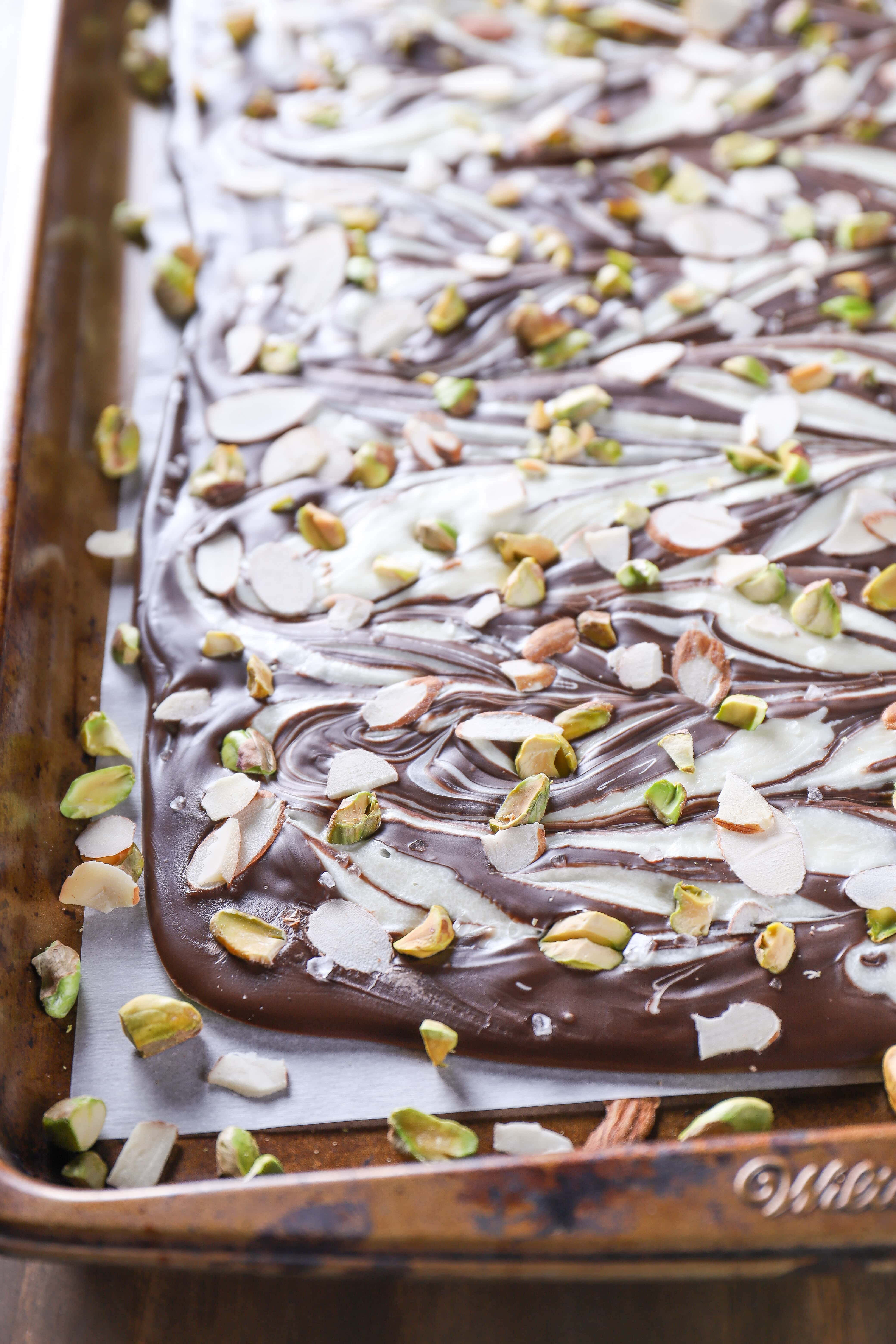 Pan of Swirled Dark Chocolate Almond Pistachio Bark. Recipe from A Kitchen Addiction