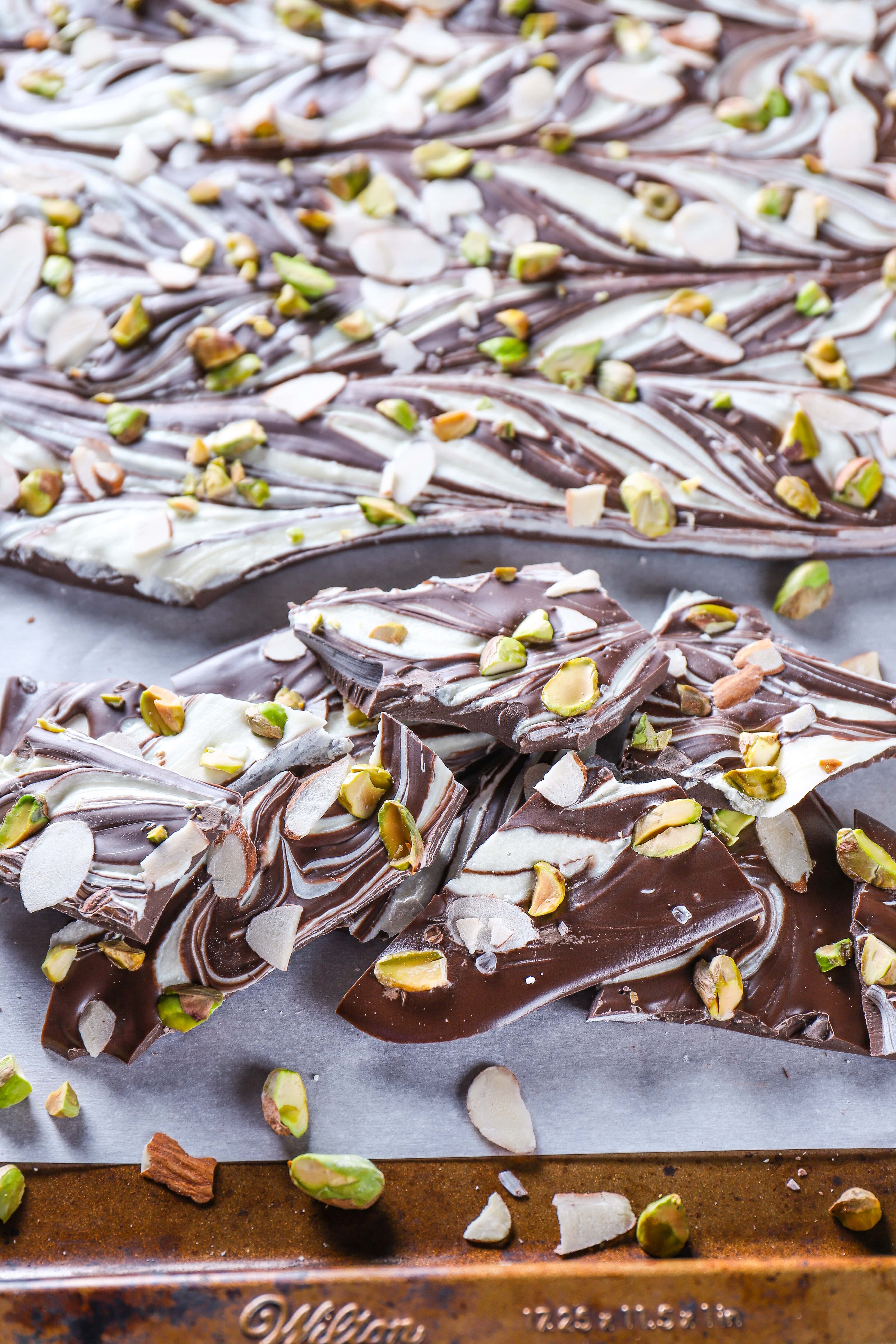 Pieces of Swirled Dark Chocolate Almond Pistachio Bark on a baking sheet.