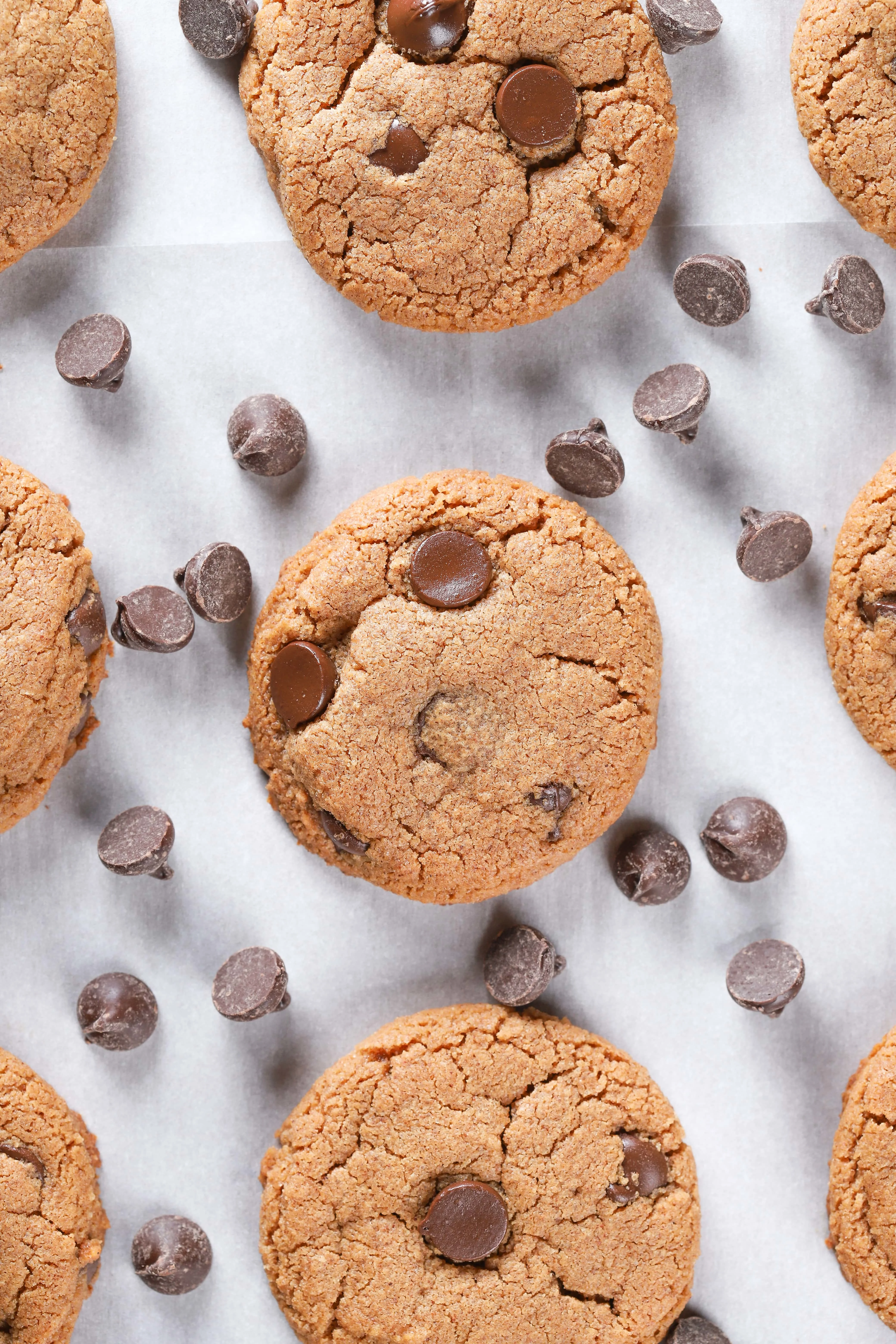 Overhead view of a baking sheet full of flourless almond butter chocolate chip cookies. Recipe for cookies found on A Kitchen Addiction.