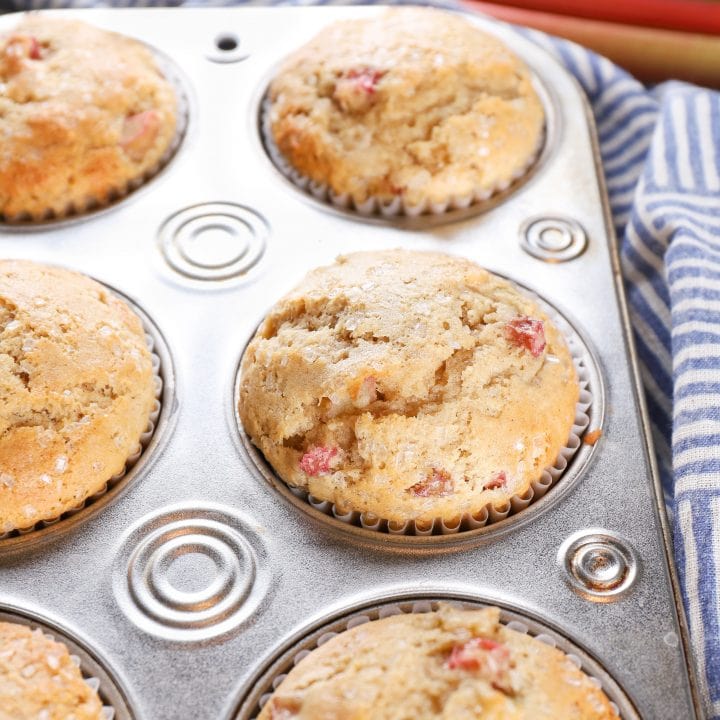 Muffin tin full of bakery style rhubarb muffins