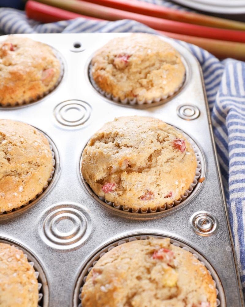 Muffin tin full of bakery style rhubarb muffins