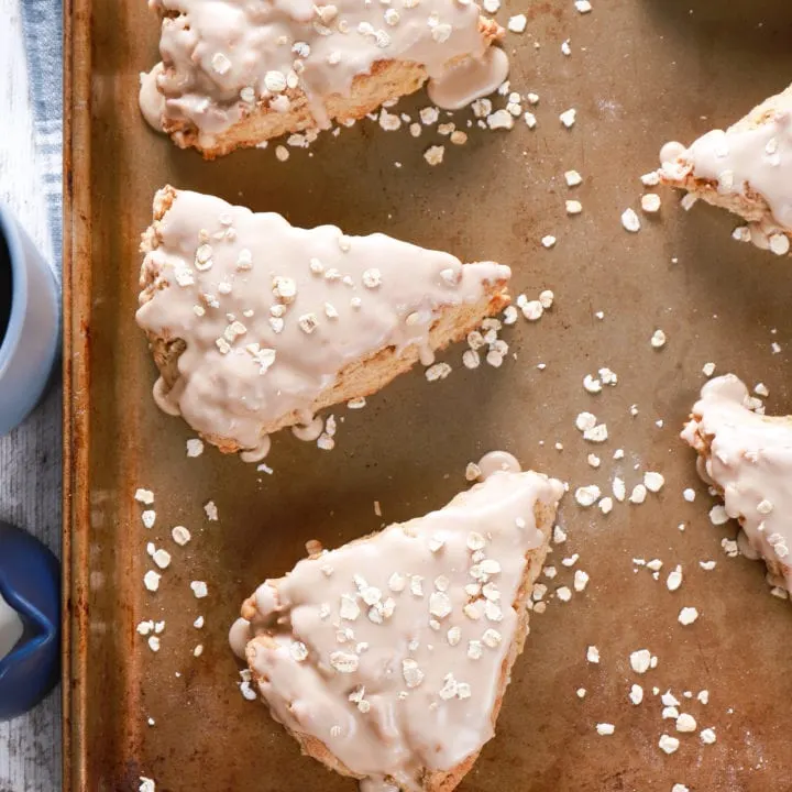 Overhead view of maple oat scones on a baking sheet. Recipe from A Kitchen Addiction