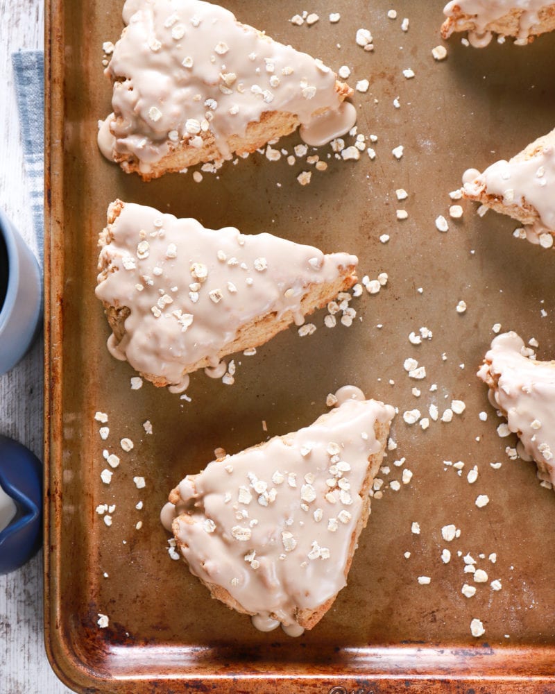 Overhead view of maple oat scones on a baking sheet. Recipe from A Kitchen Addiction