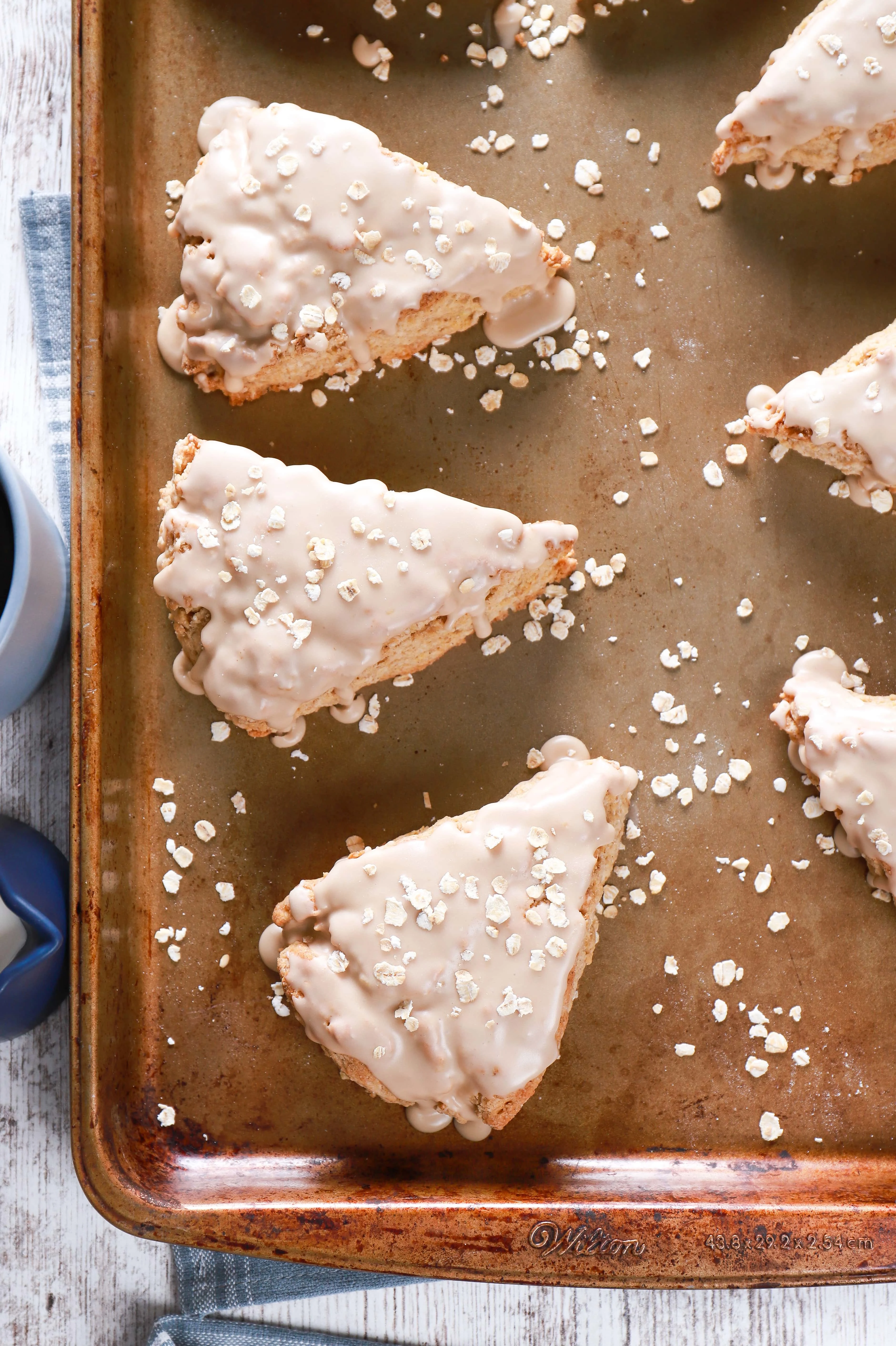 Overhead view of maple oat scones on a baking sheet. Recipe from A Kitchen Addiction