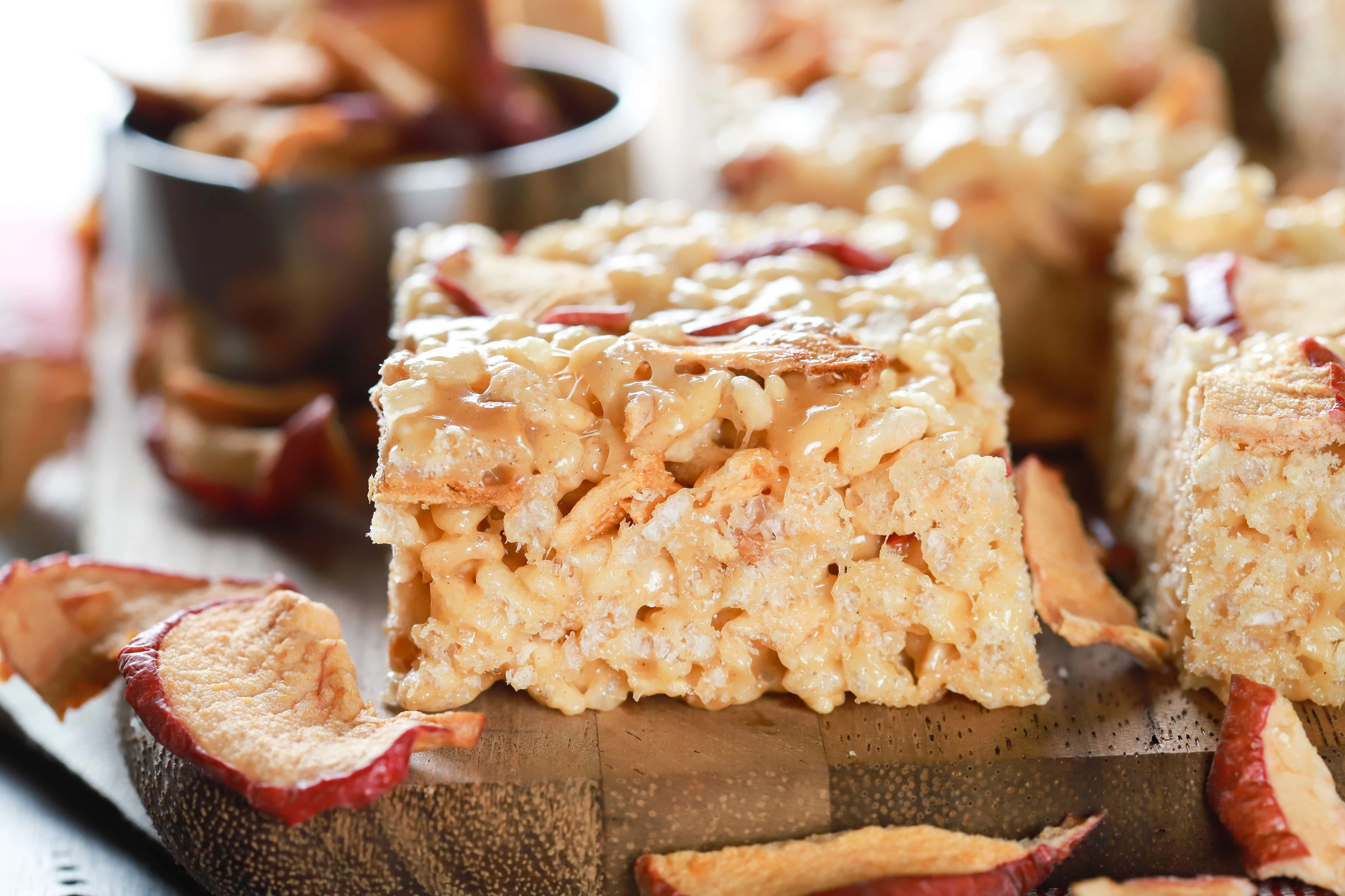 Up close side view of an apple peanut butter rice crispy treat on a cutting board. Recipe from A Kitchen Addiction