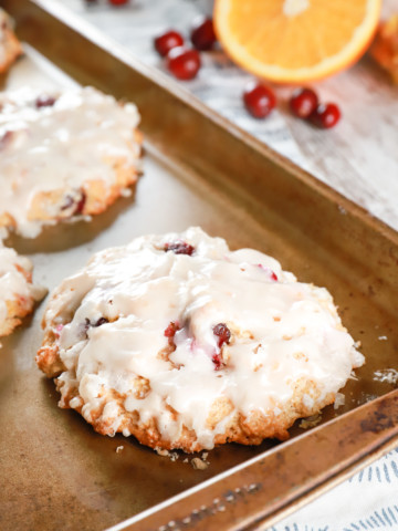 Baked cranberry orange fritters on a baking sheet. Recipe from A Kitchen Addiction