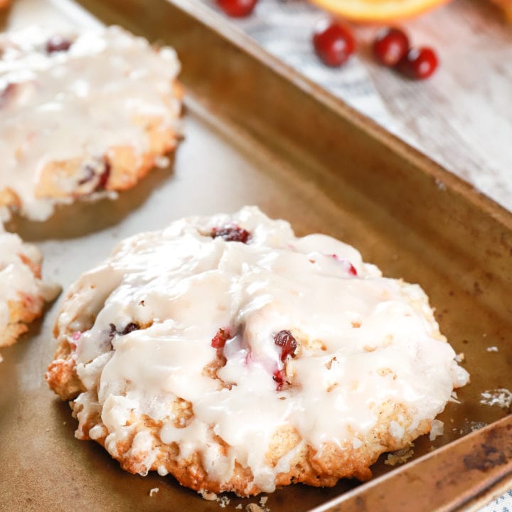 Baked cranberry orange fritters on a baking sheet. Recipe from A Kitchen Addiction