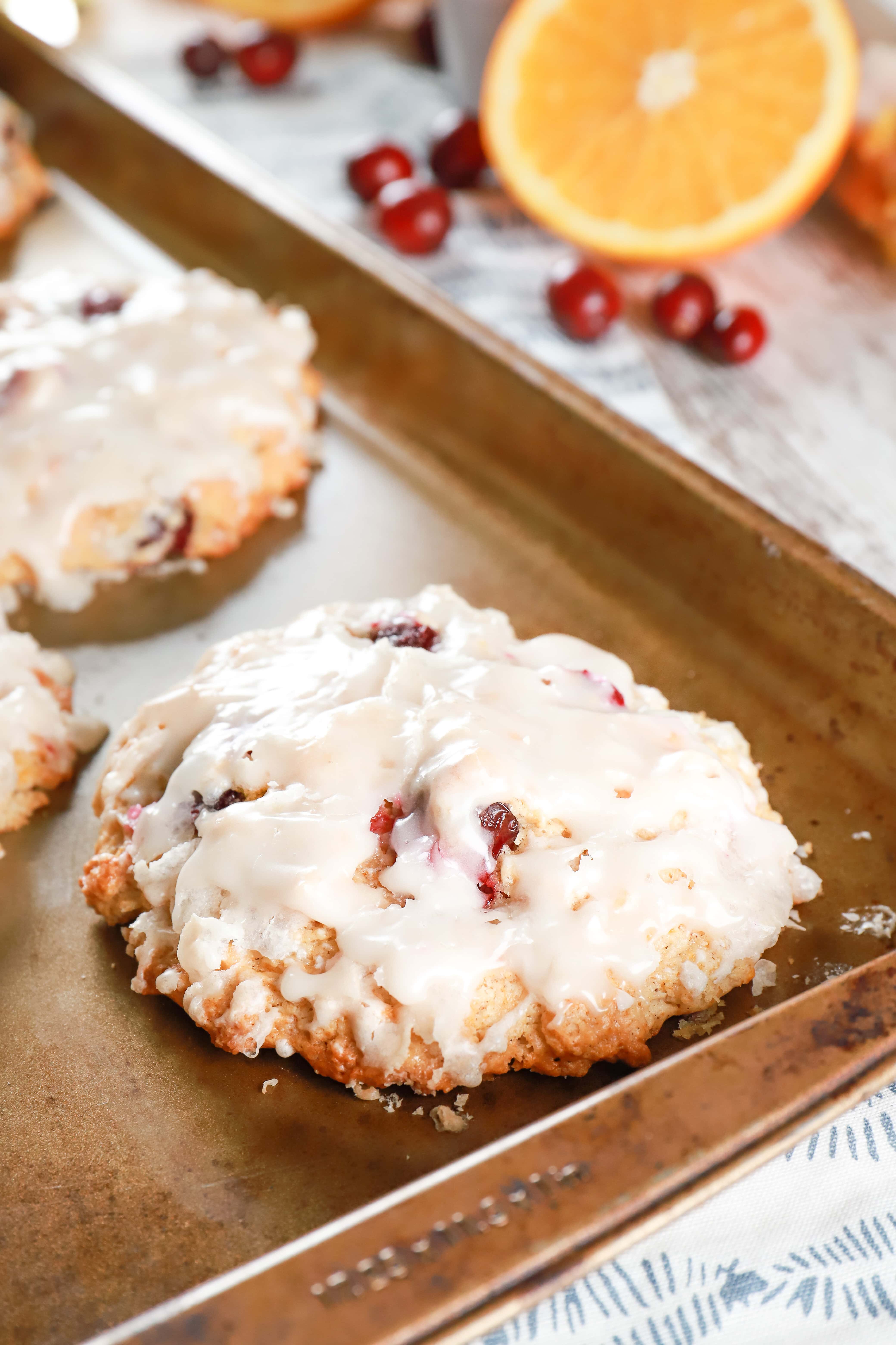 Baked cranberry orange fritters on a baking sheet. Recipe from A Kitchen Addiction