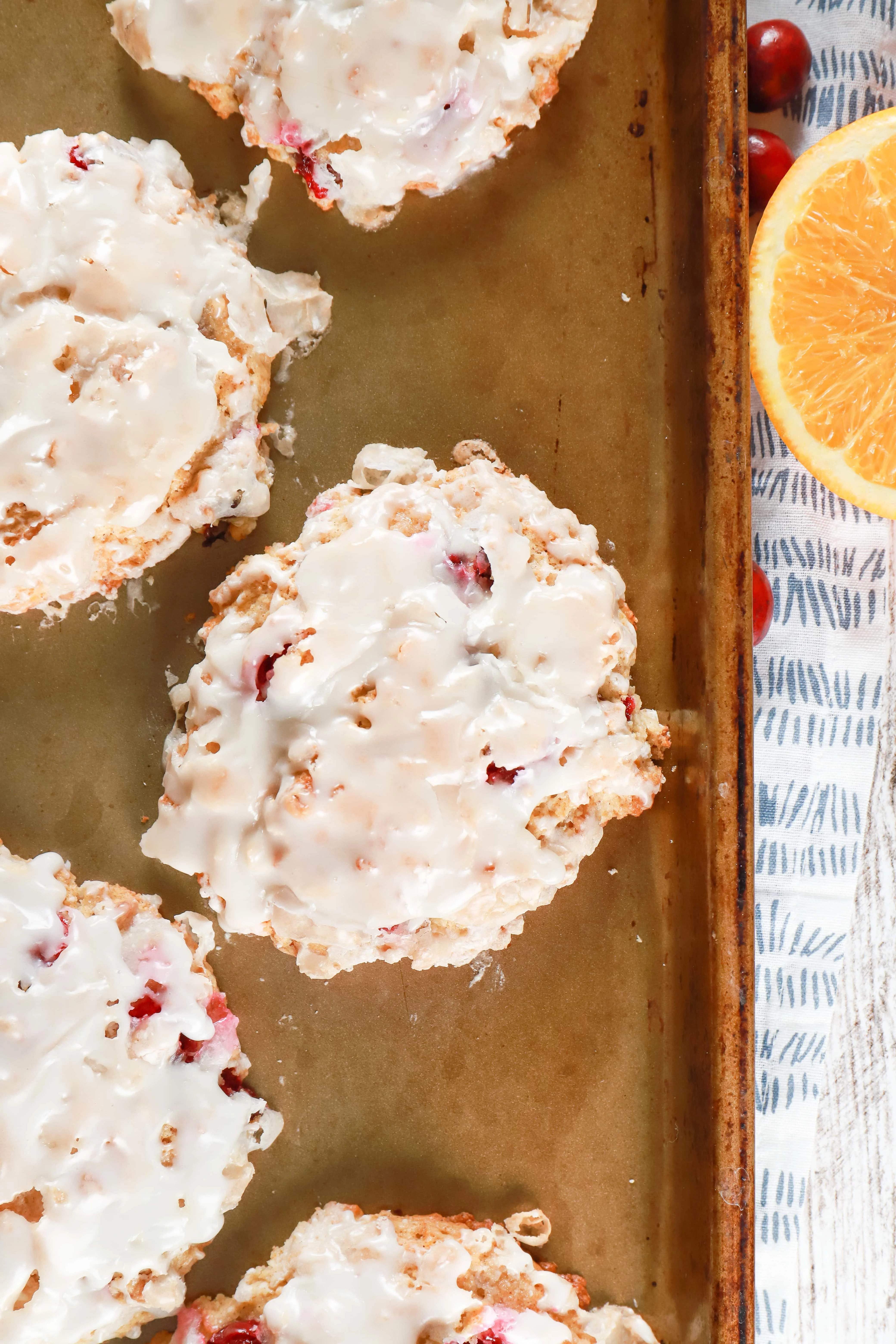 Overhead view of a baked cranberry orange fritter on a baking sheet.