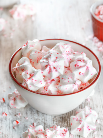 Small white bowl full of Mini Peppermint Meringue Cookies. Recipe from A Kitchen Addiction