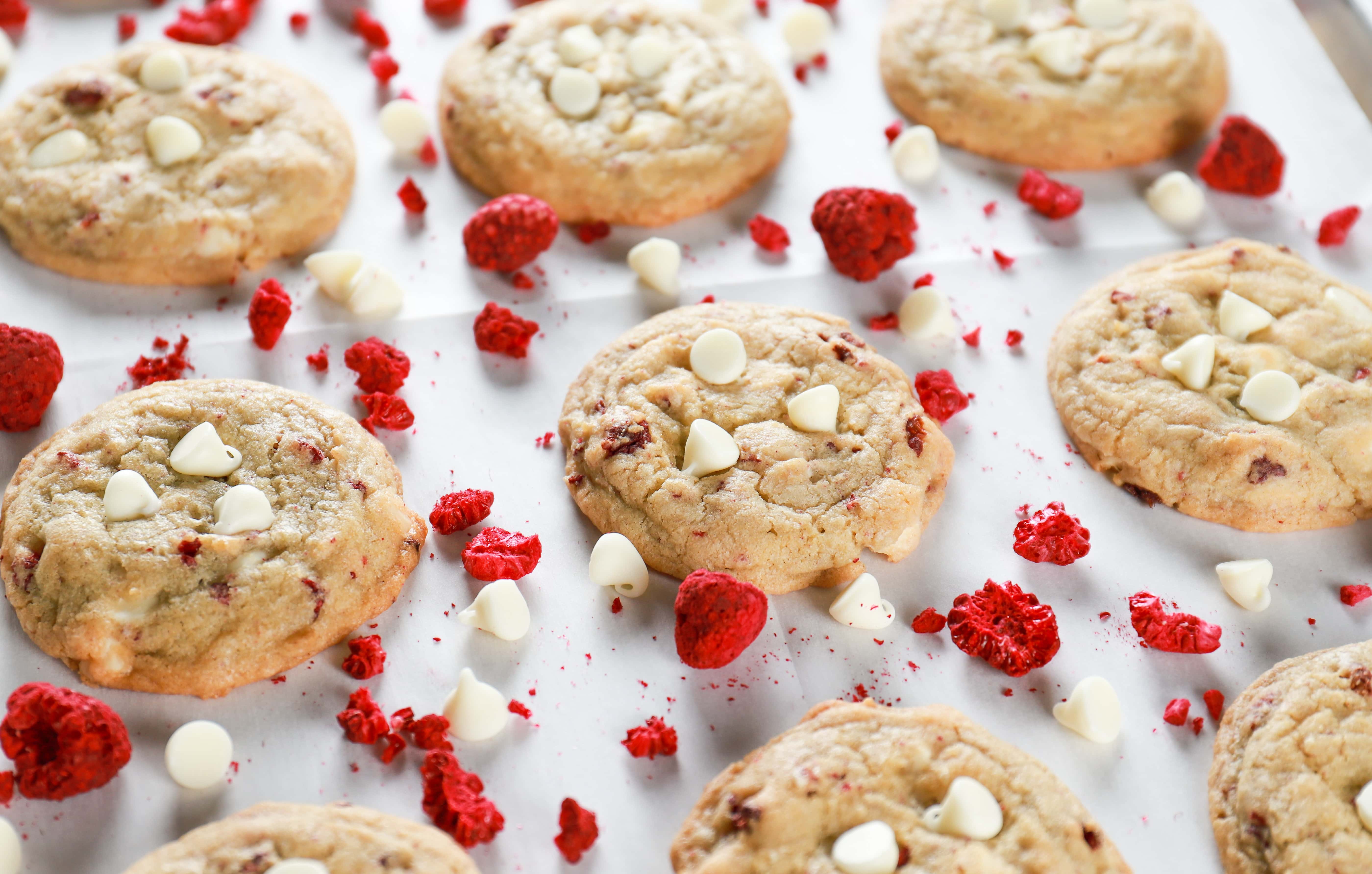 Chewy white chocolate raspberry cookies on a parchment paper lined baking sheet. Recipe from A Kitchen Addiction