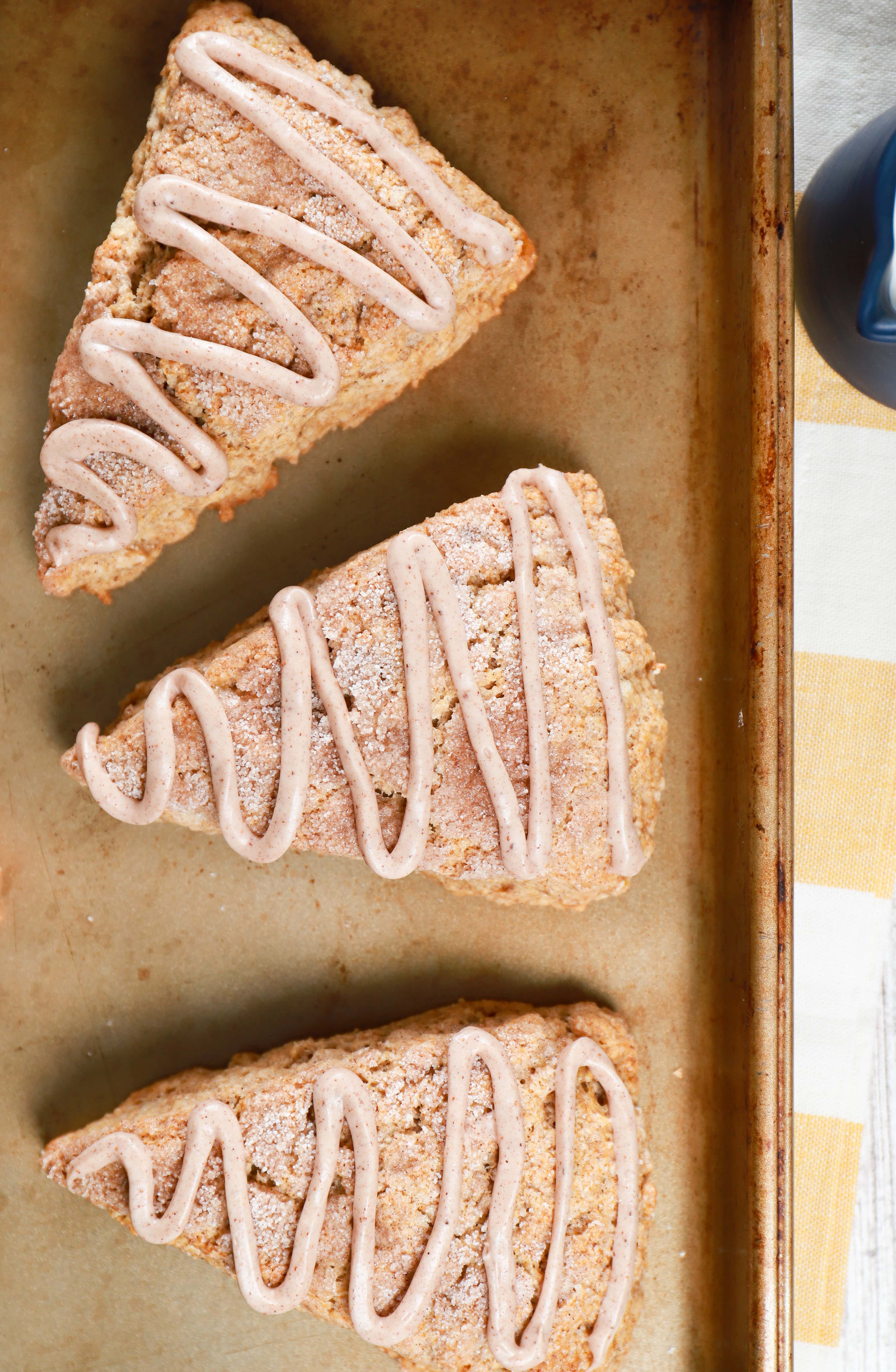 Overhead view of 3 snickerdoodle banana scones on a baking sheet. Recipe for scones from A Kitchen Addiction