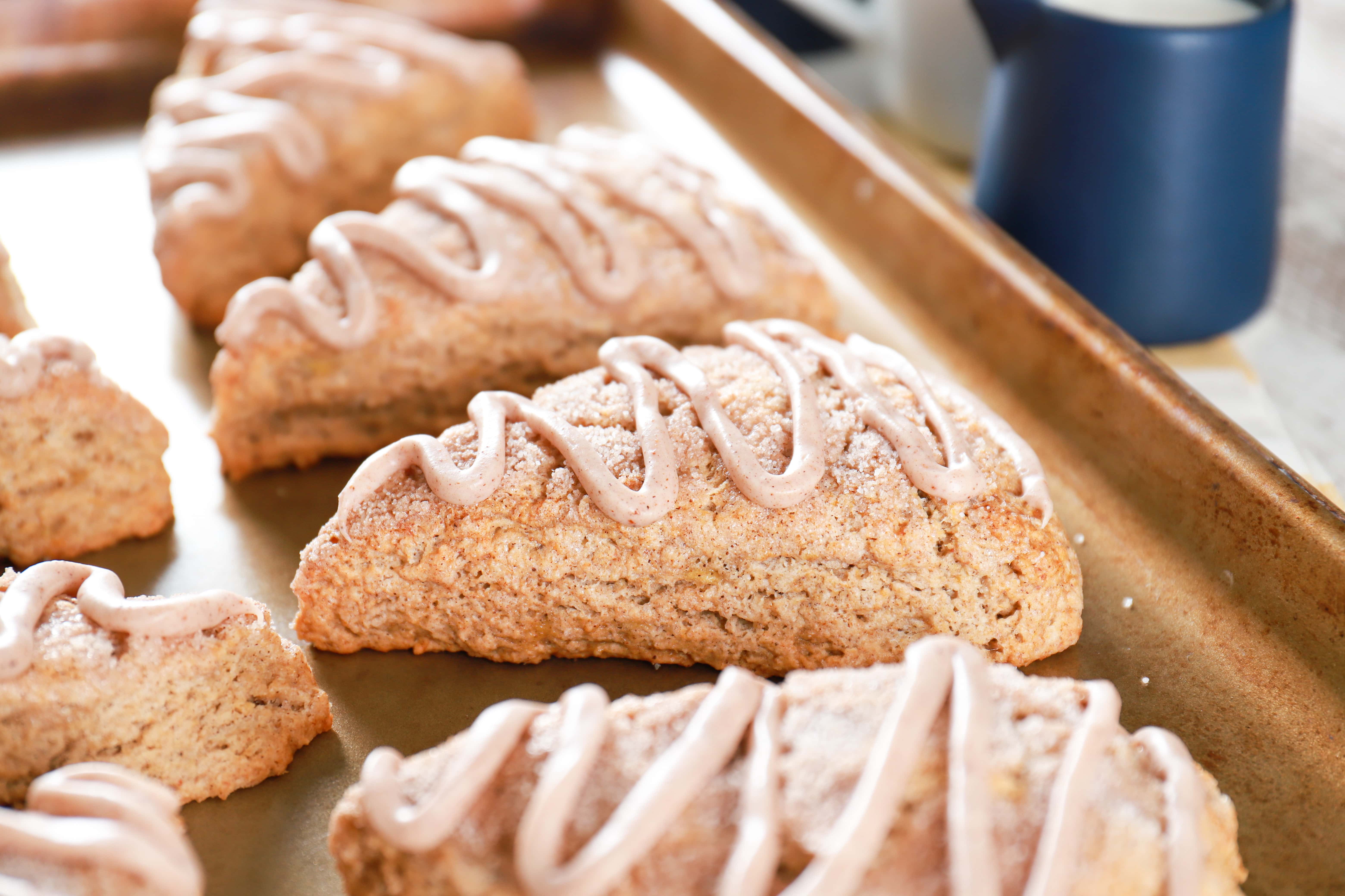 Up close photo of a glazed banana snickerdoodle scone on a baking sheet. Recipe from A Kitchen Addiction