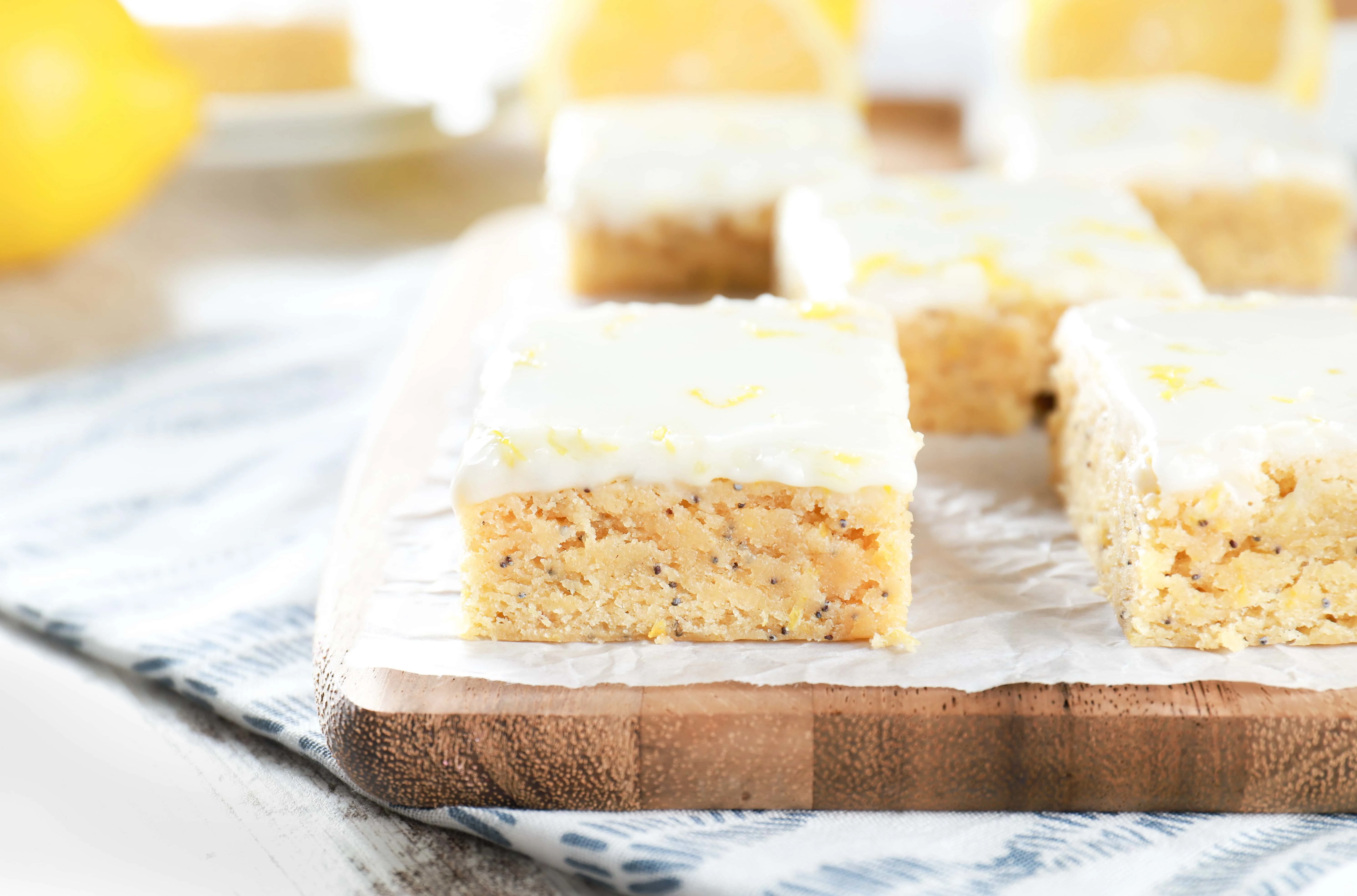 Up close image of a poppy seed bar on a cutting board. Recipe for bars from A Kitchen Addiction