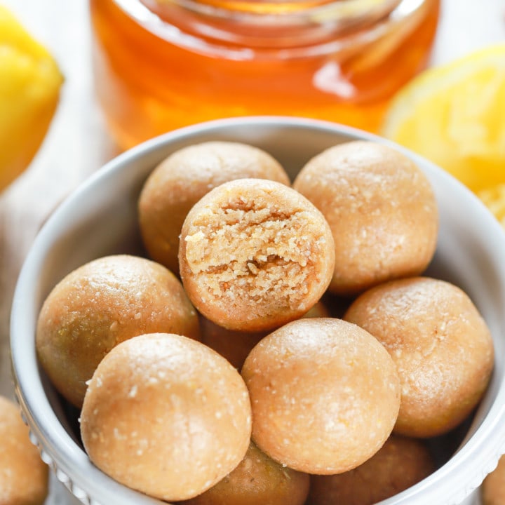 Up close image of a lemon protein bite with a bite taken out of it. Recipe from A Kitchen Addiction