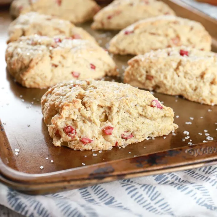 Up close image of a rhubarb scone with more scones in the background. Recipe from A Kitchen Addiction