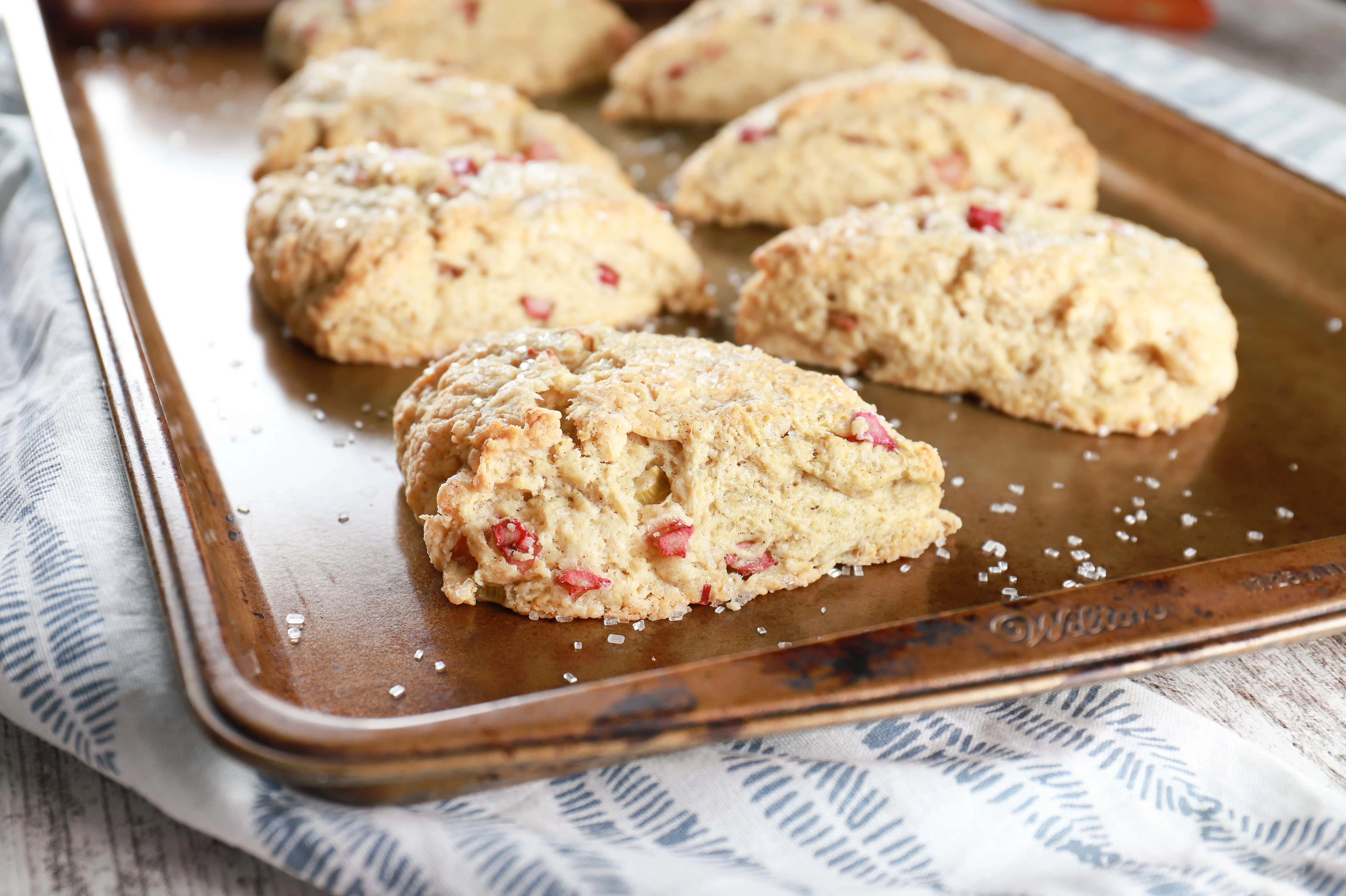 Up close image of a rhubarb scone with more scones in the background. Recipe from A Kitchen Addiction