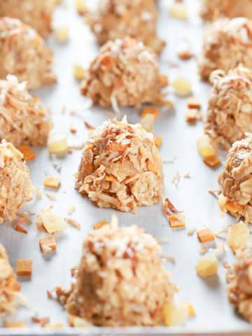 Tropical no bake cookies on a parchment paper lined baking sheet. Recipe for cookies from A Kitchen Addiction