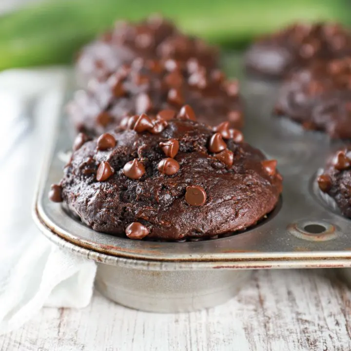 Up close side view of a bakery style double chocolate zucchini muffin. Recipe from A Kitchen Addiction